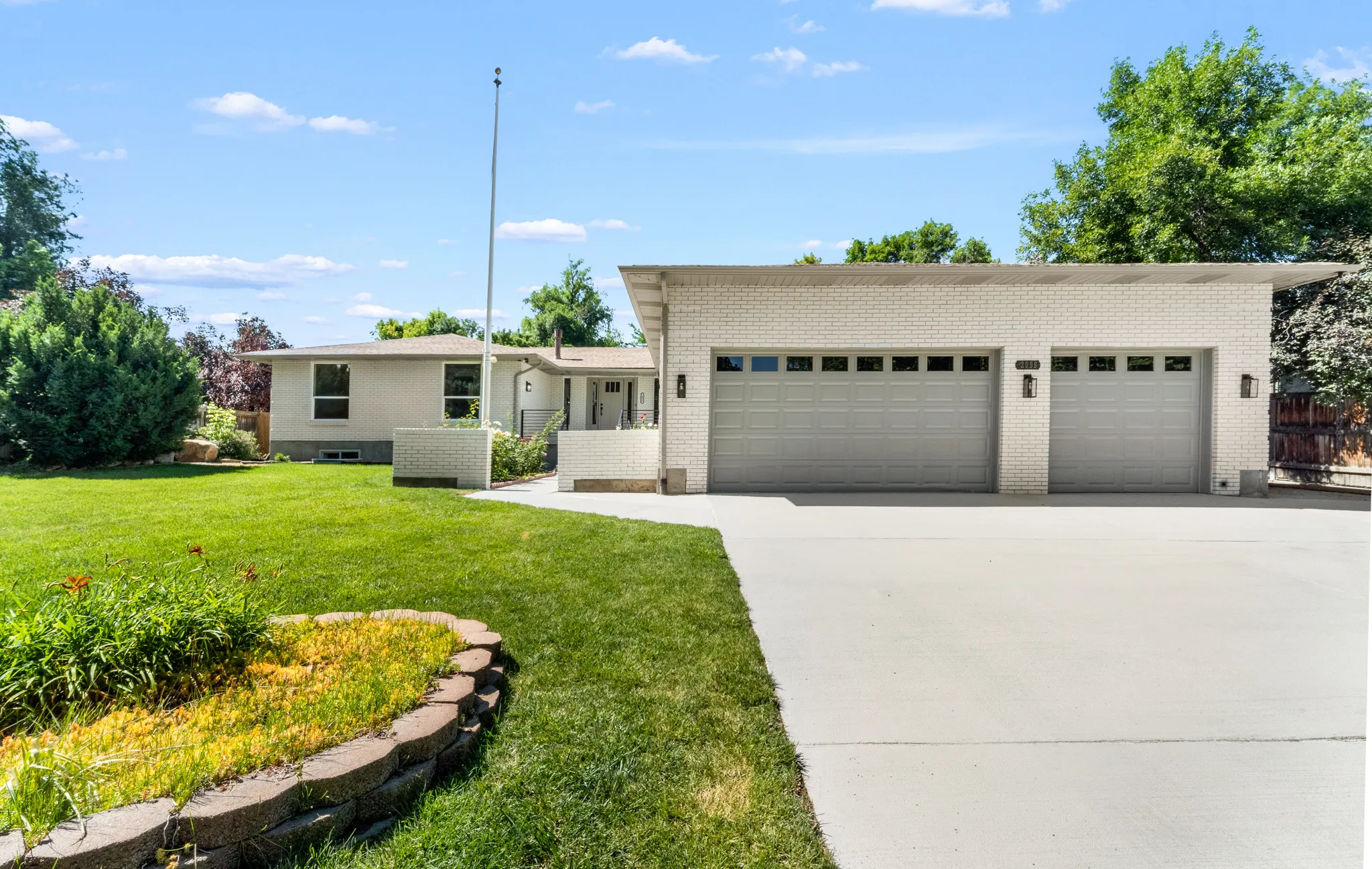 Expansive front yard featuring a manicured lawn and mature landscaping