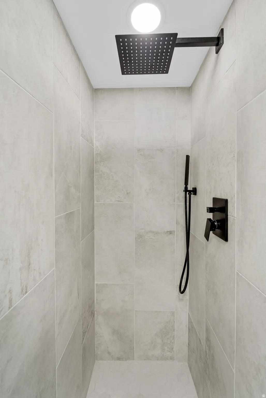 Walk-in shower featuring matte black fixtures, a square rain showerhead, a handheld shower, a tiled surround, and recessed lighting