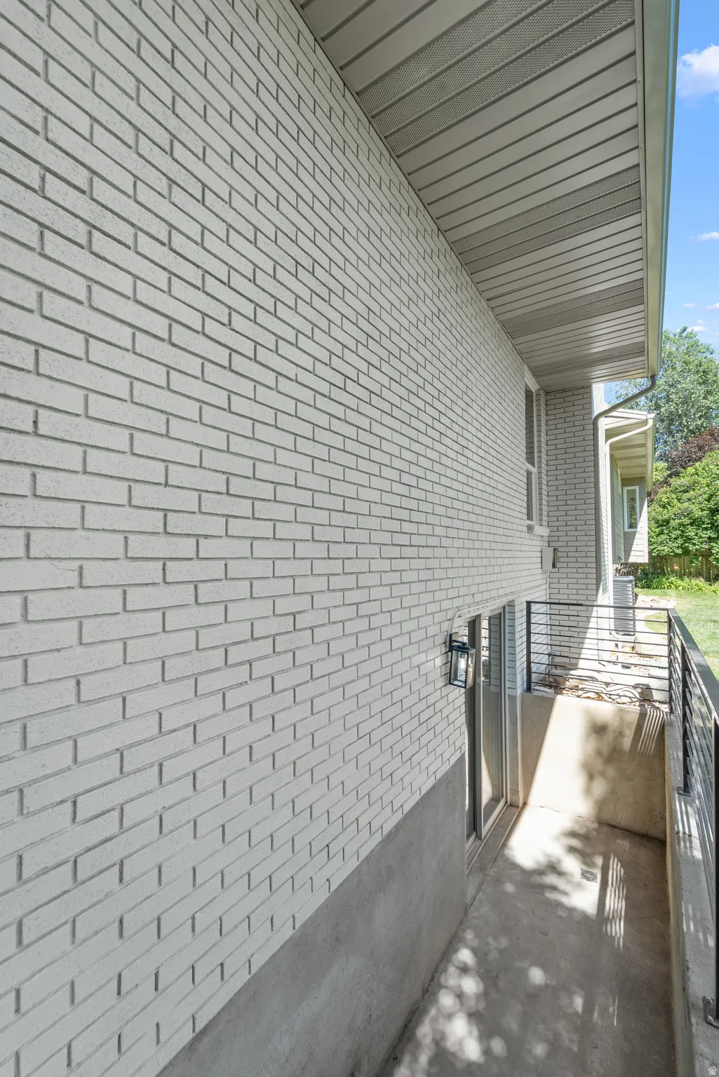 Light-colored brick exterior with a lower concrete foundation