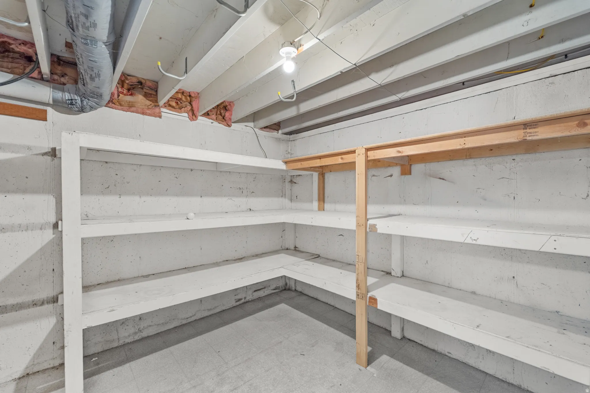 Unfinished basement with concrete flooring and exposed ceiling joists