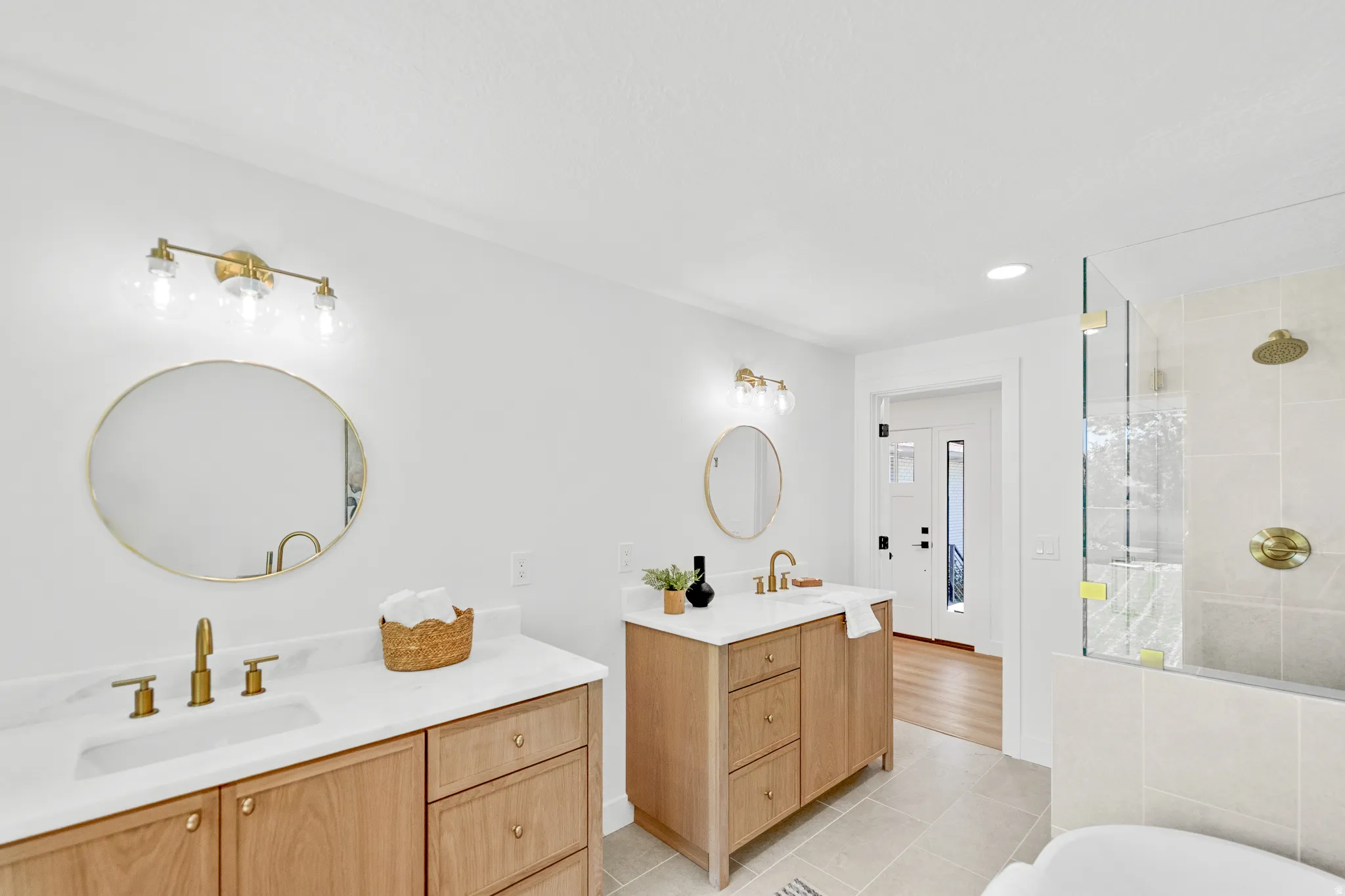 Dual wood-finish vanities with white countertops and gold-finish fixtures