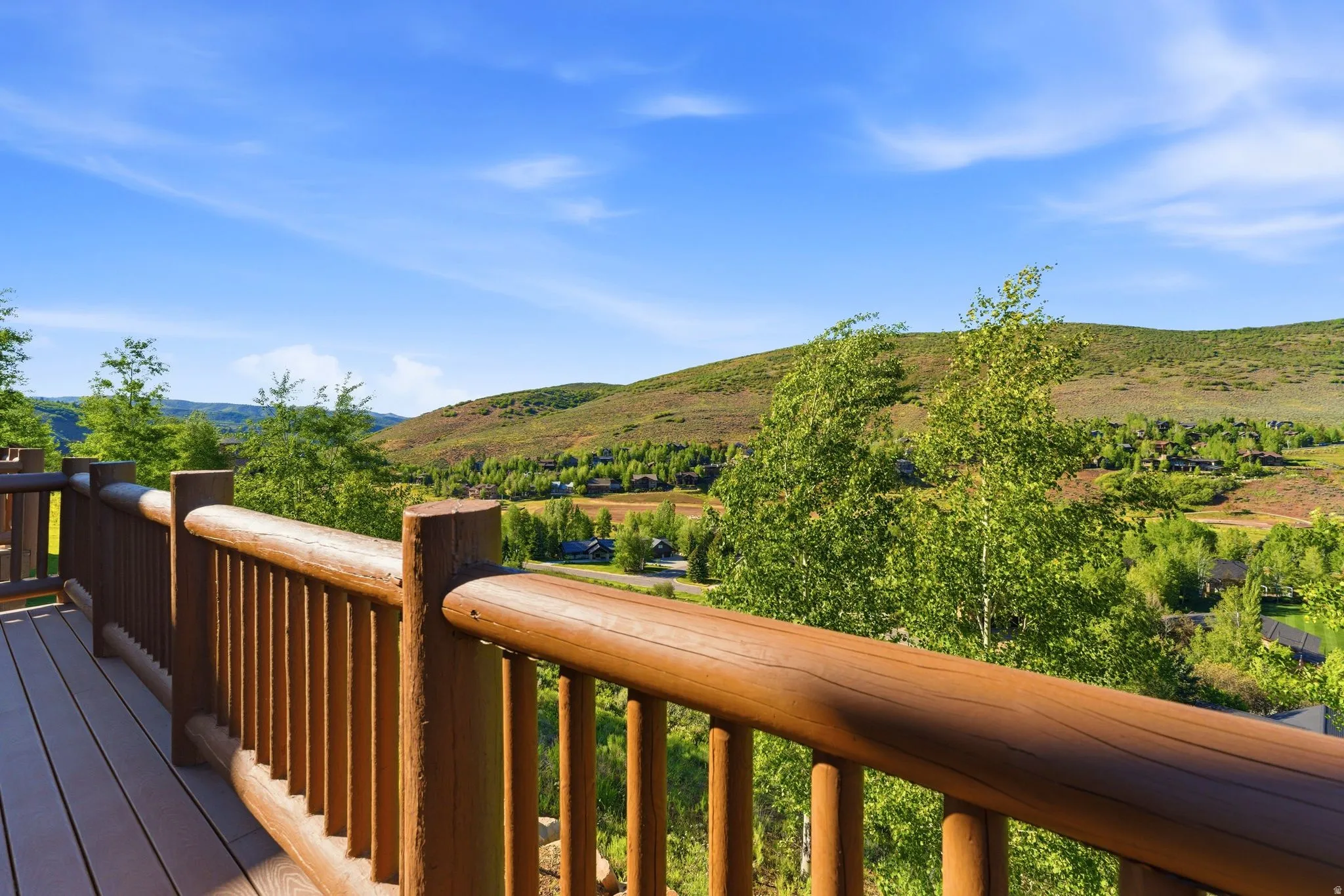Expansive outdoor deck featuring wood-finish railing and decking