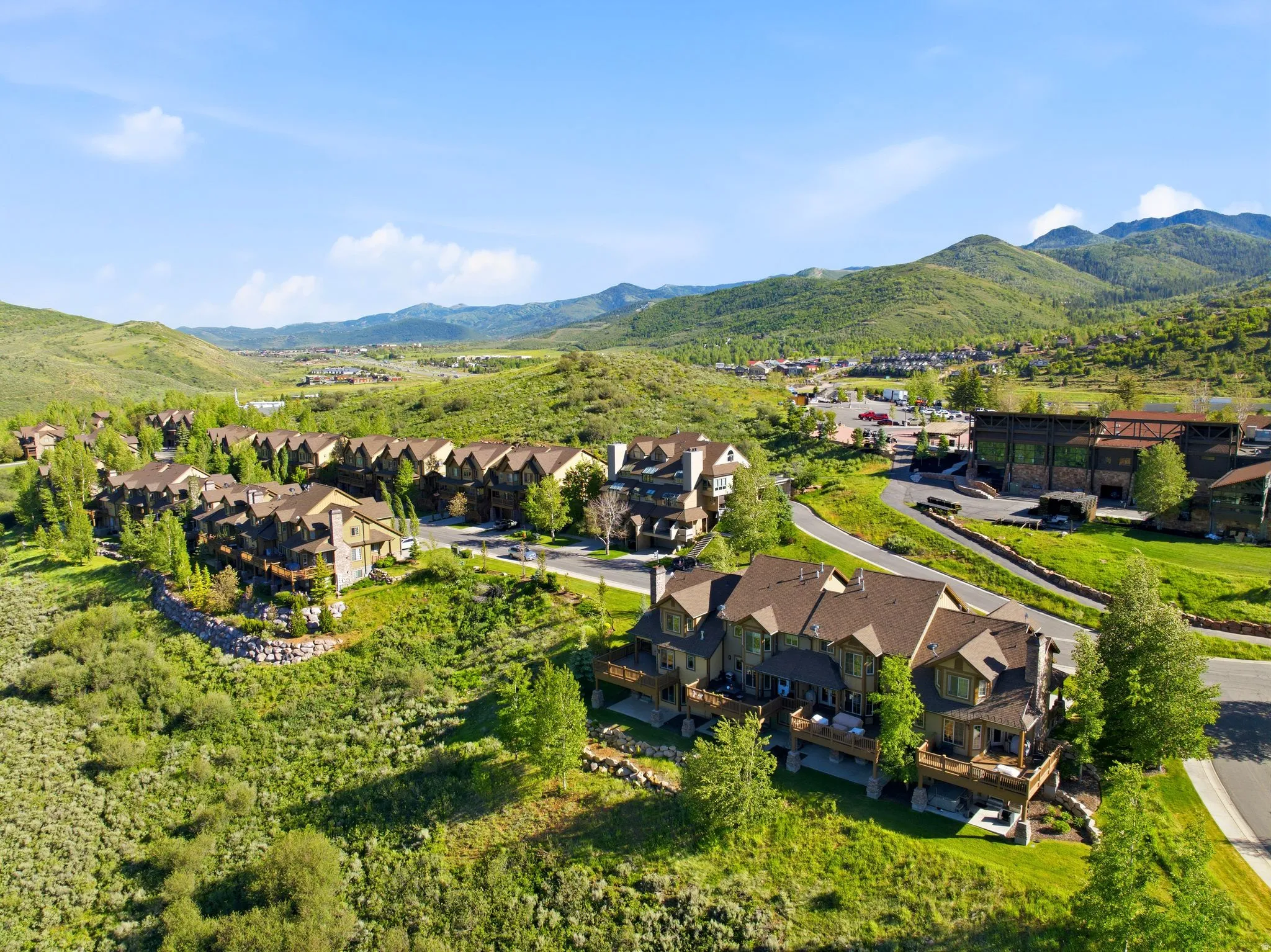 Expansive property featuring multiple residential structures with brown roofing and stone accents