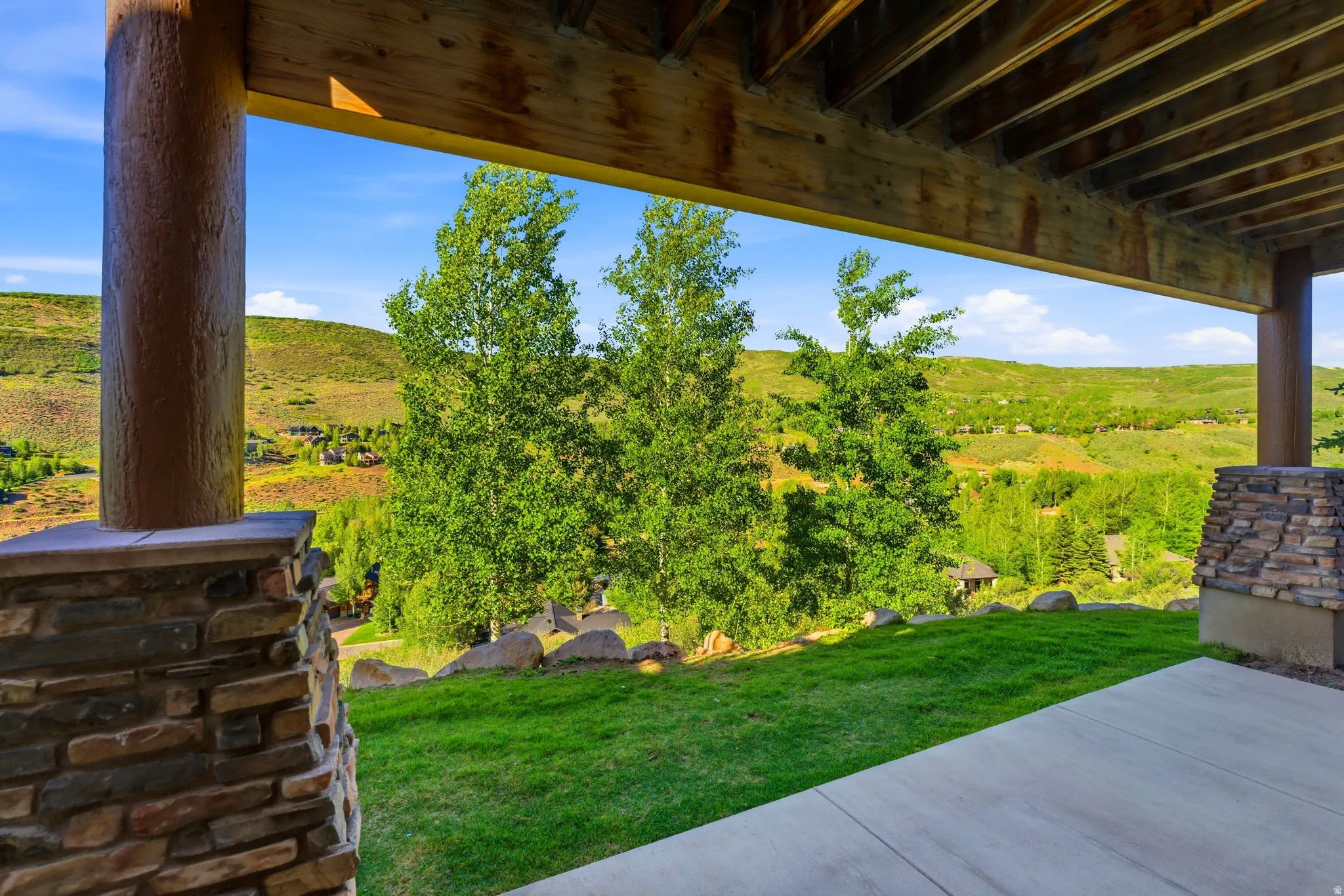 Covered patio featuring a concrete surface and a stone-clad pillar
