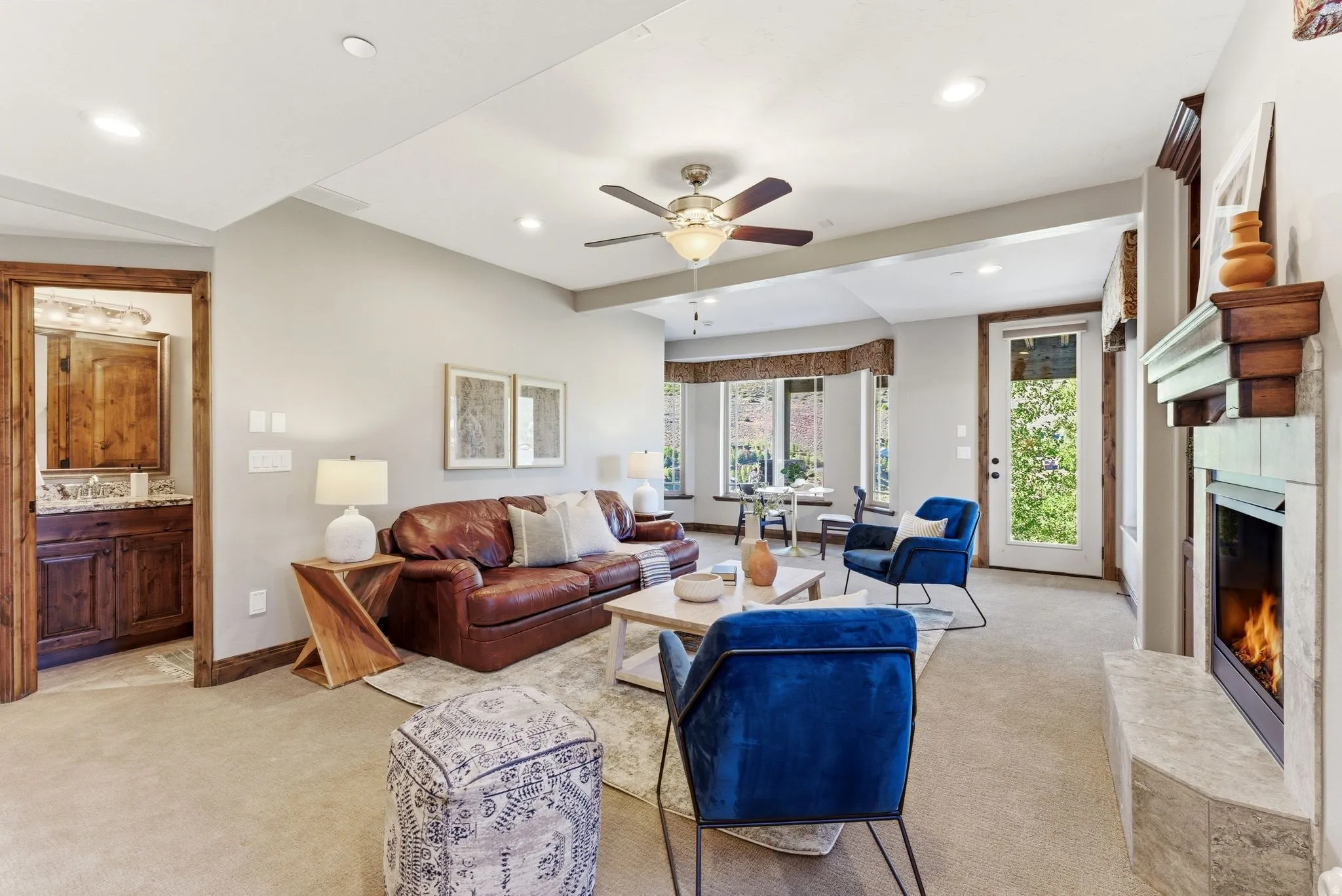 Spacious living area featuring a built-in fireplace with a stone hearth, recessed lighting, and a ceiling fan