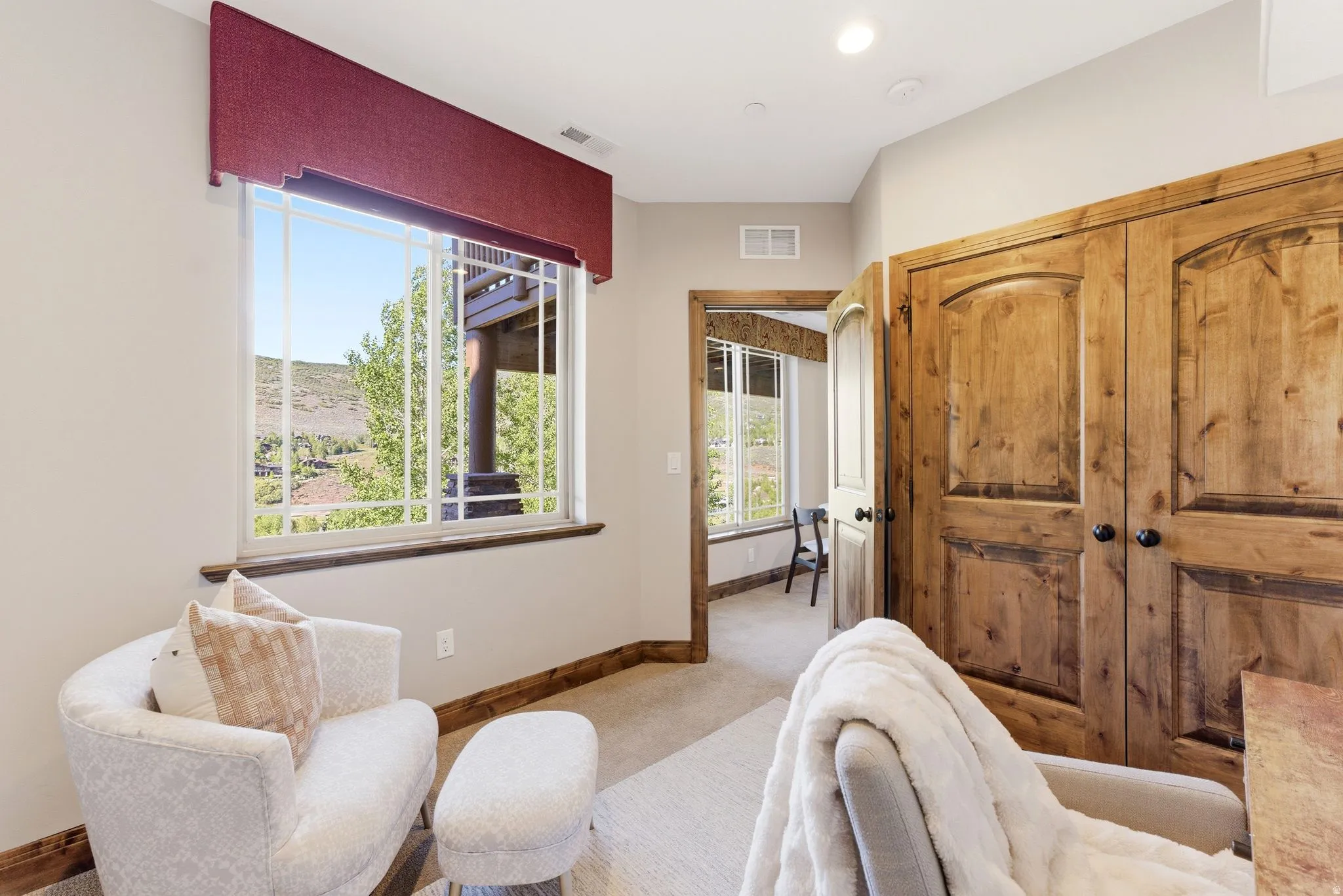 Large window with a red valance, offering a mountain backdrop