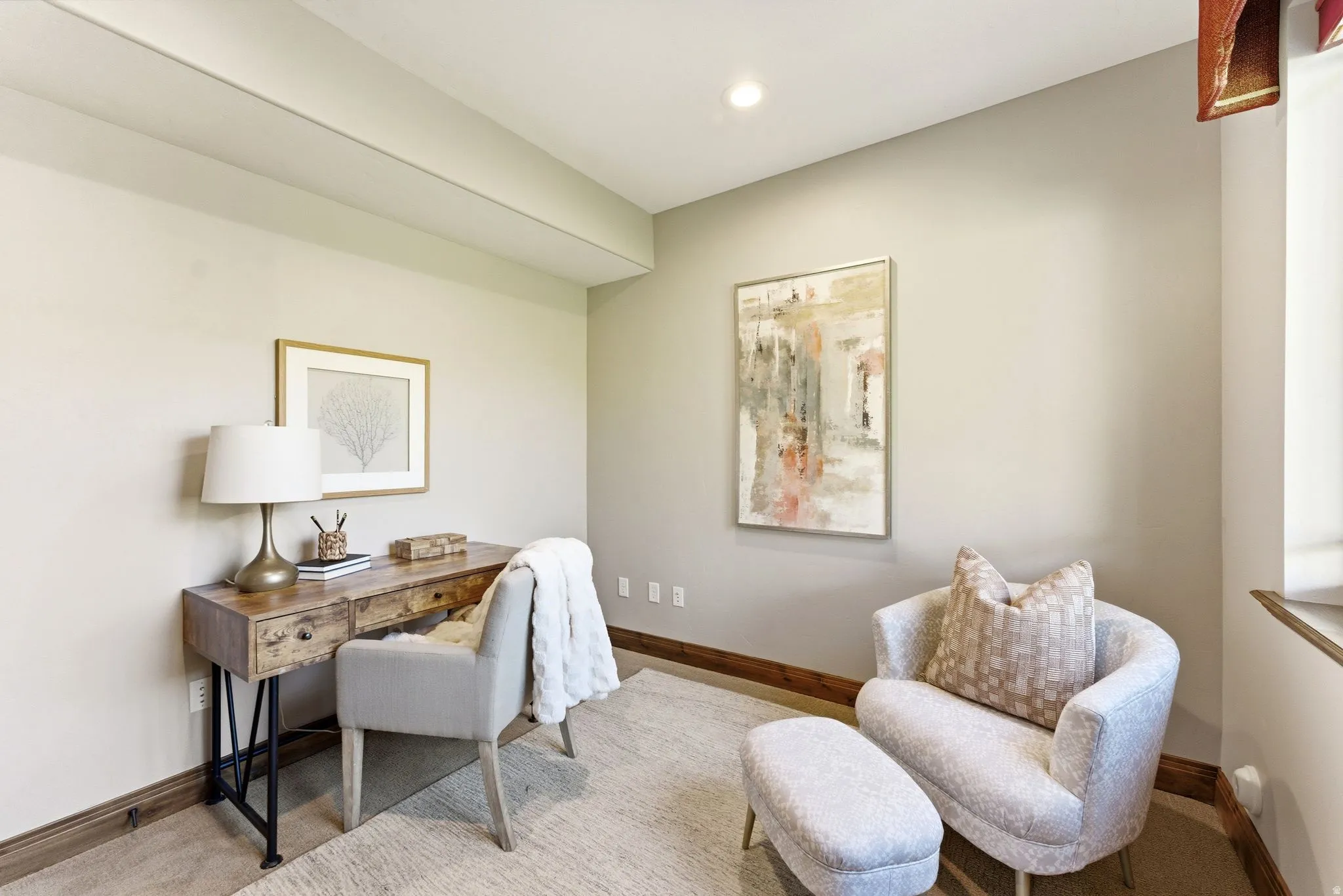 Recessed lighting illuminates a versatile room with light-toned walls and wood-finish baseboards
