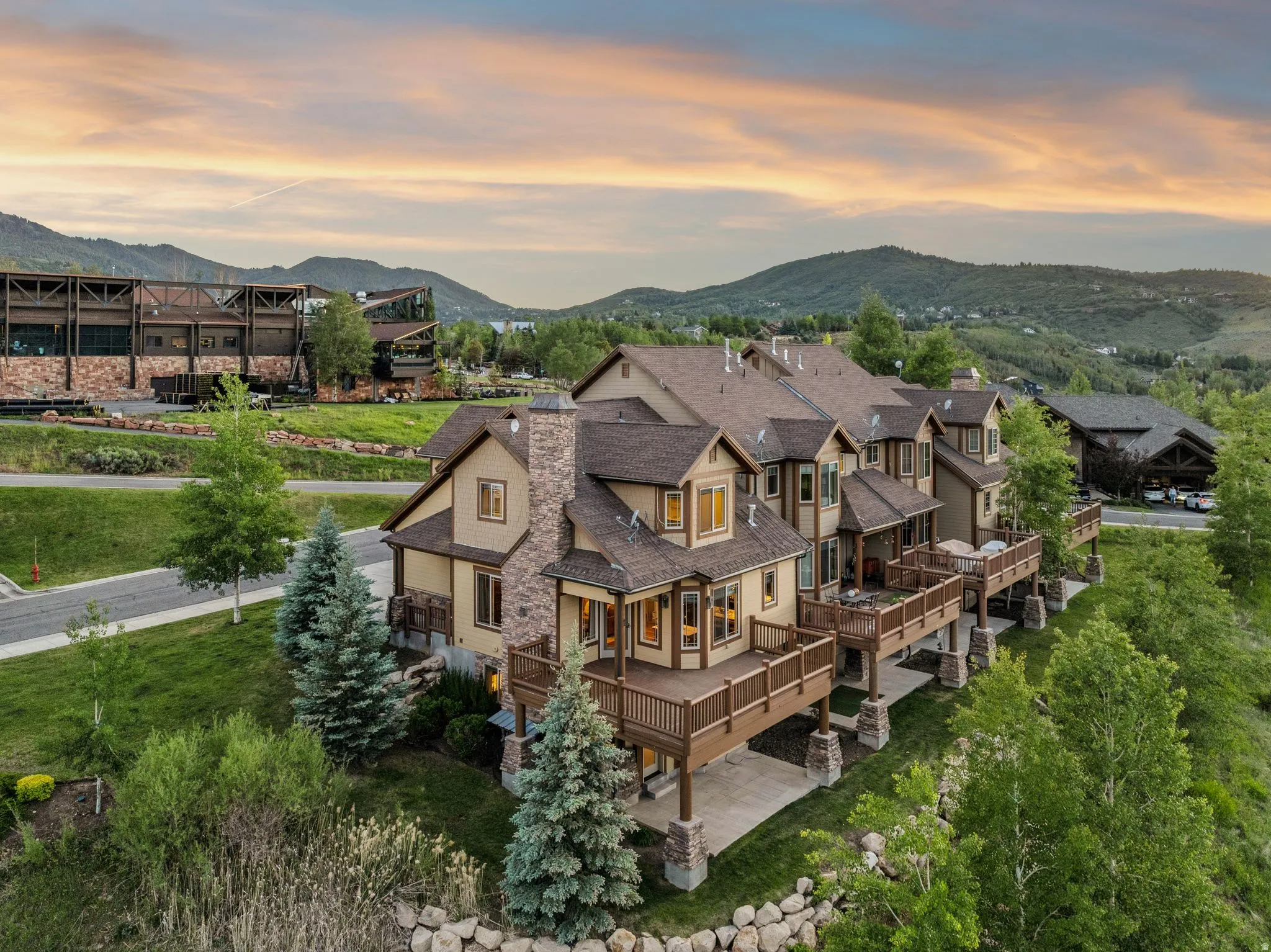 Multi-level residence featuring extensive outdoor decking, stone accents, and a pitched roofline