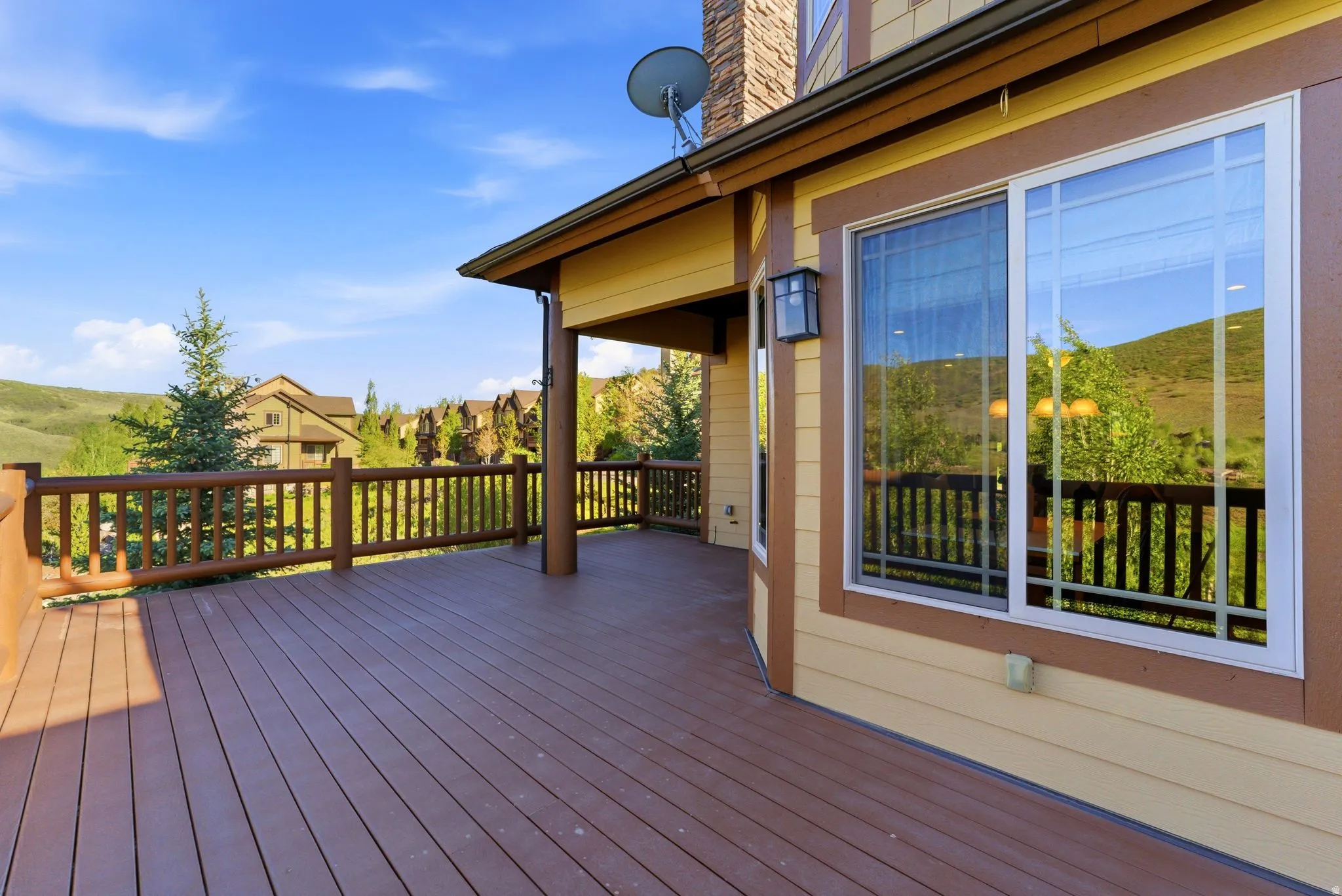 Spacious outdoor deck featuring composite decking and a log-style railing