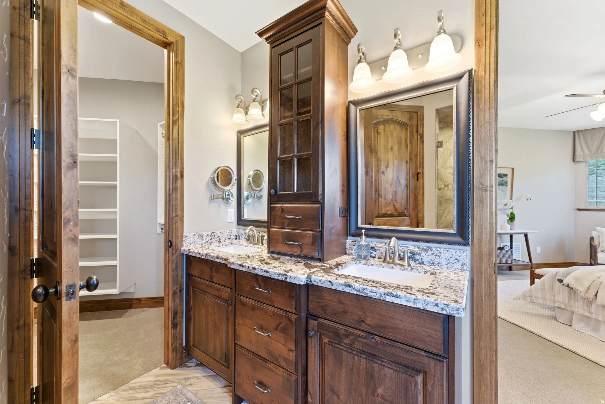 Double vanity featuring wood cabinetry, integrated sinks, and a stone-finish countertop