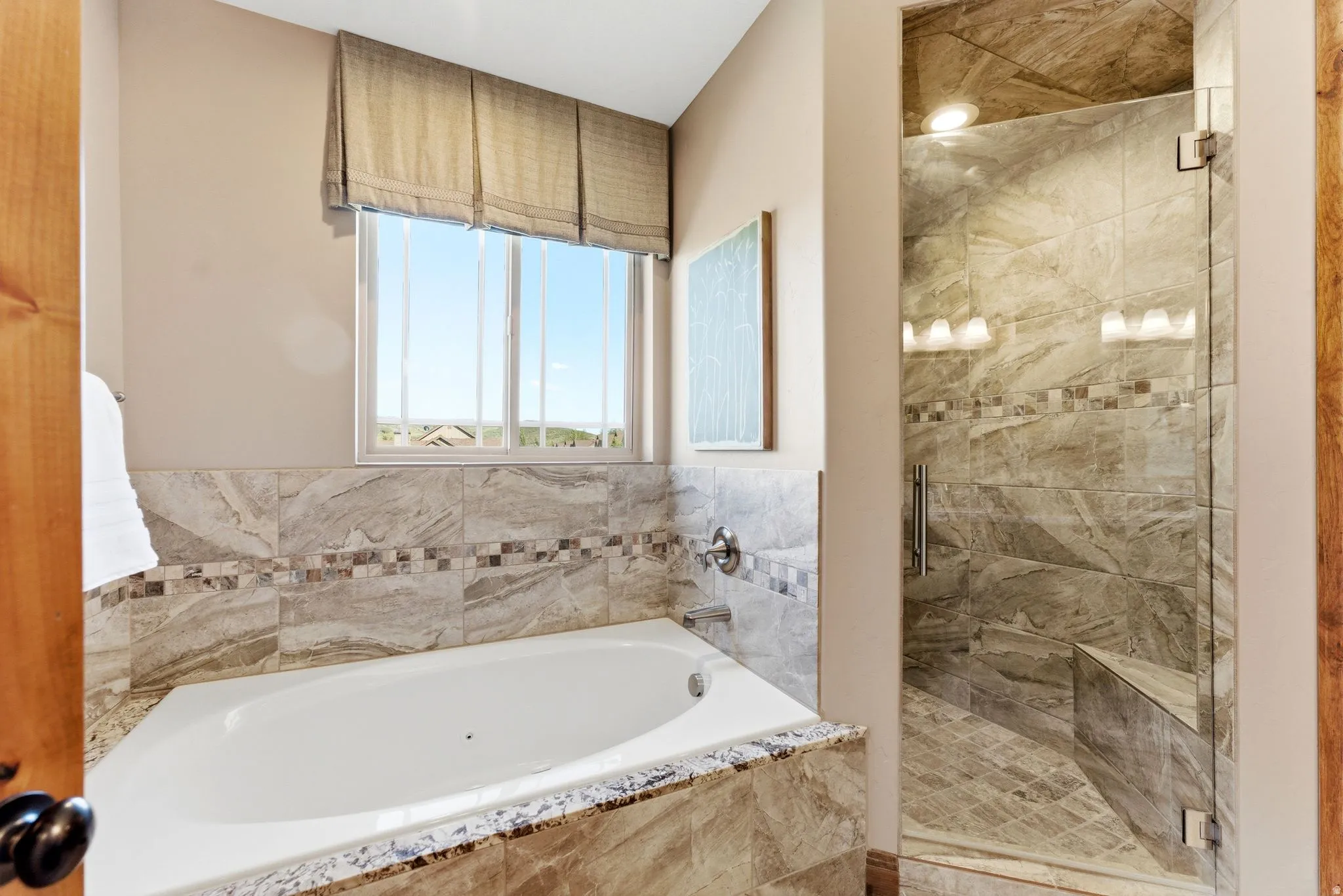 Spa-inspired bathroom featuring a built-in soaking tub with a tiled surround and a separate glass-enclosed shower