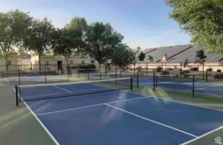 Outdoor recreation area featuring multiple courts with blue and green surfacing, black netting, and surrounding fencing