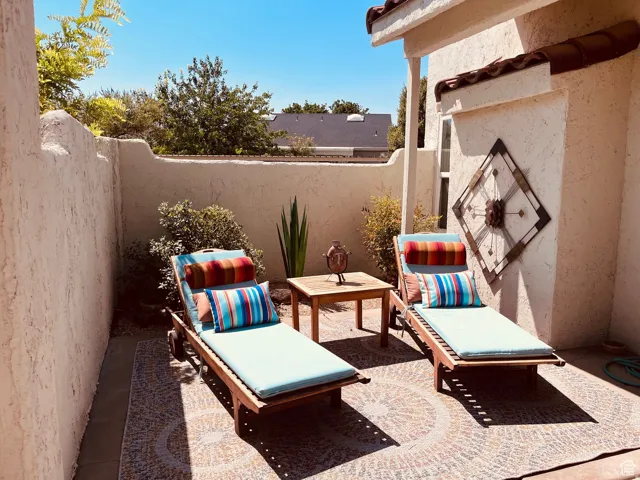 Private outdoor patio area featuring textured stucco walls and a terra cotta tile roofline