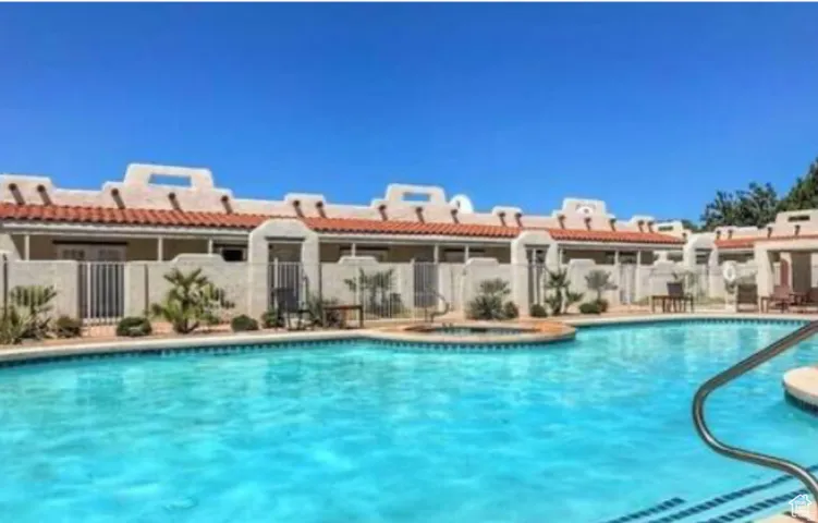 Community swimming pool with an integrated spa, surrounded by a paved deck