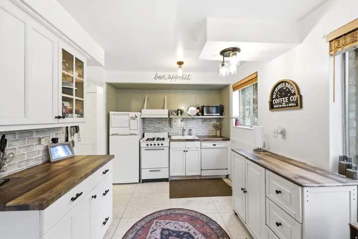 White cabinetry throughout featuring glass-front uppers and black hardware