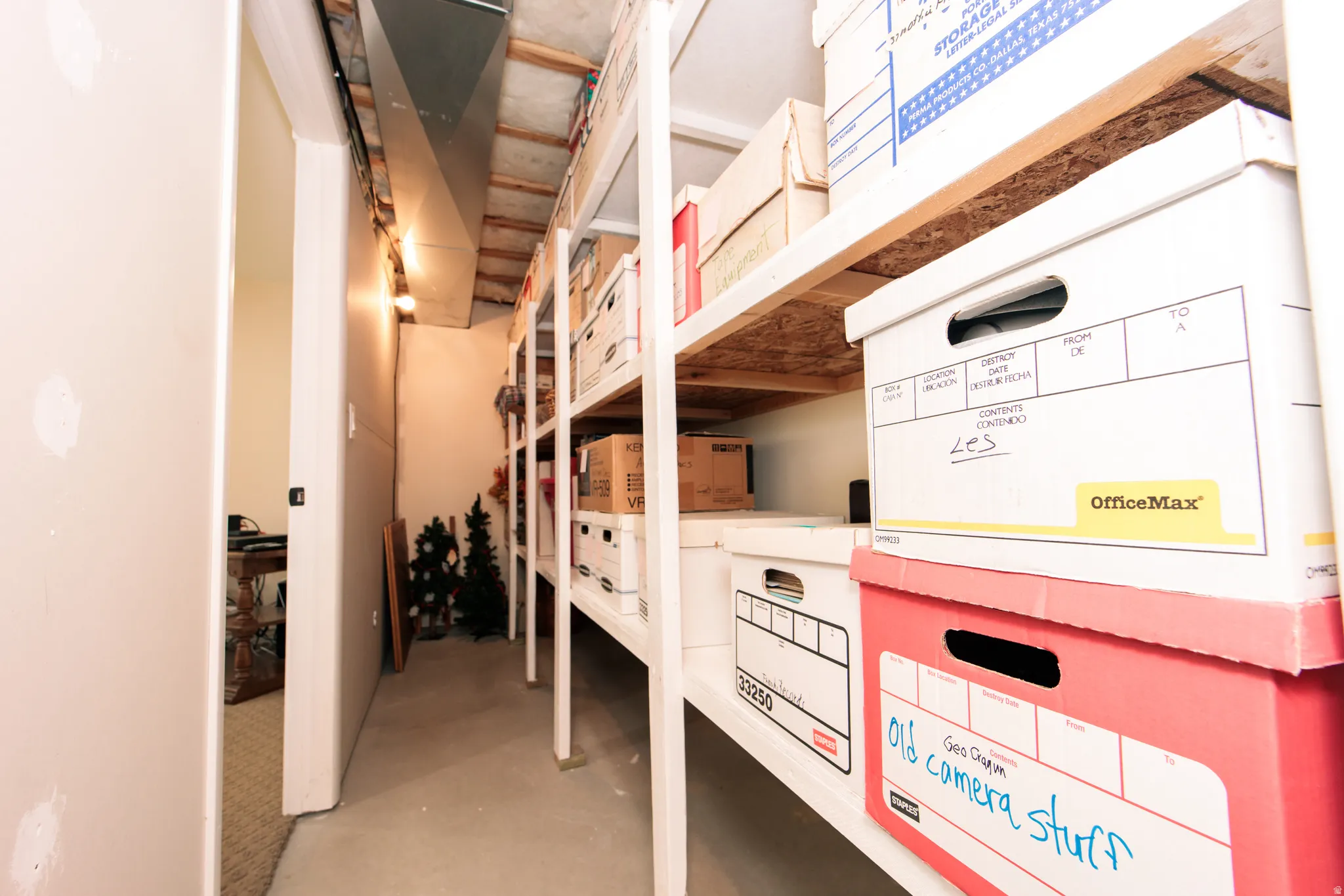 Utility storage area featuring exposed ductwork and open shelving with wood-finish tops