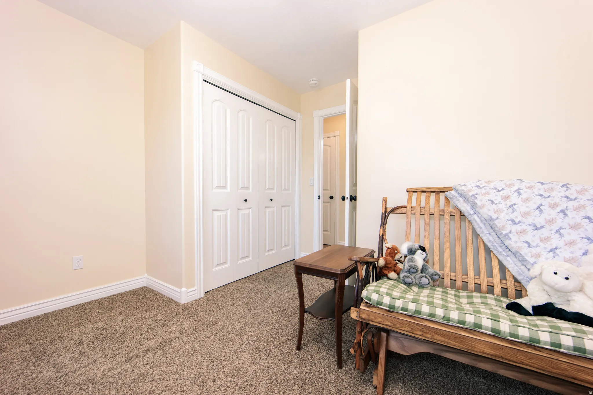 Neutral-toned interior room featuring light-colored walls and textured carpeting