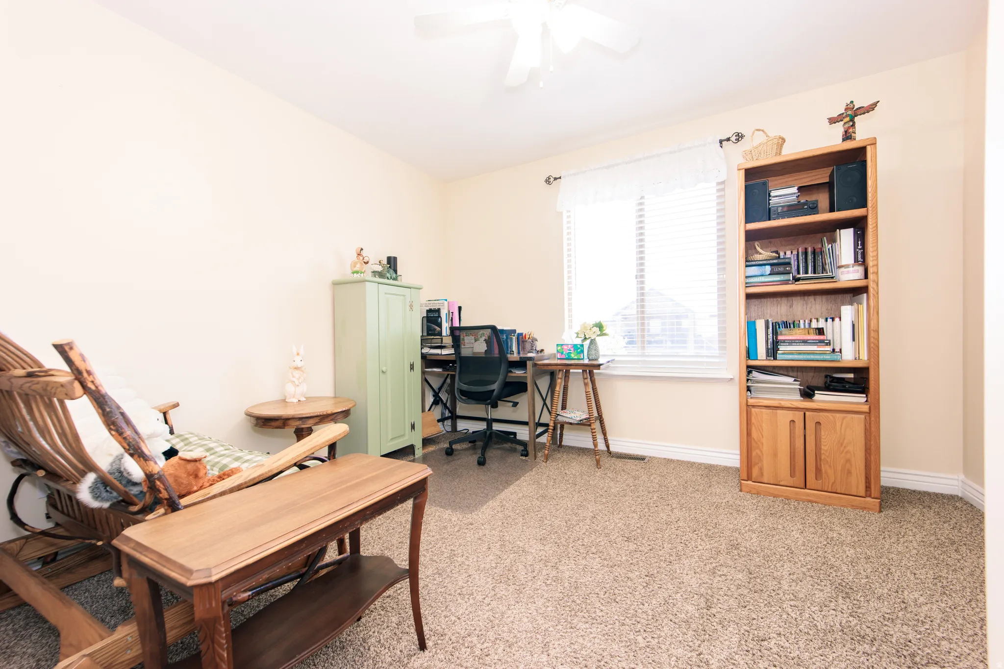 Carpeted room with a ceiling fan, a window with blinds, and white baseboards. Could also be used as a Bedroom.