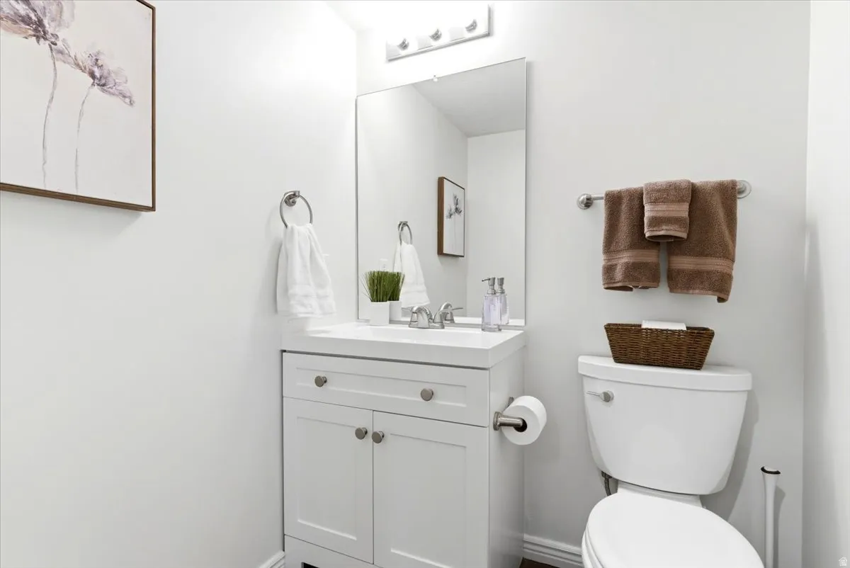 White vanity with integrated sink, chrome faucet, and mirrored medicine cabinet