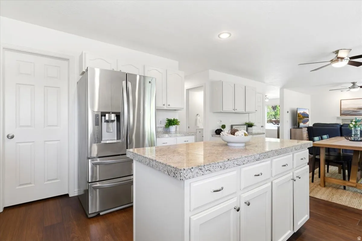 Kitchen featuring a large island with a light-toned countertop, white cabinetry, and stainless steel appliances