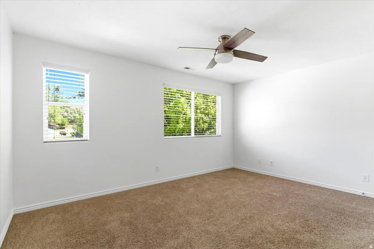 Spacious room with white walls and plush carpet flooring