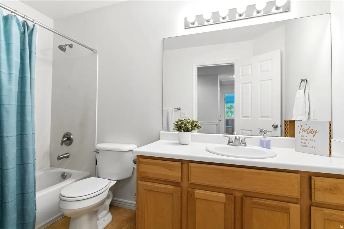 Full bathroom featuring a white tub/shower combination with chrome fixtures, a toilet, and a vanity with a white countertop