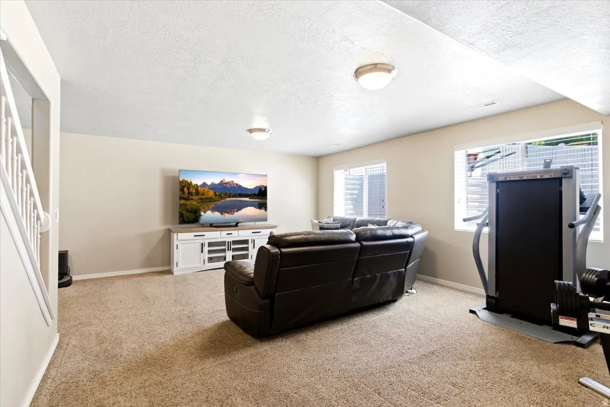 Spacious recreation area featuring neutral paint tones, recessed lighting, and carpet flooring