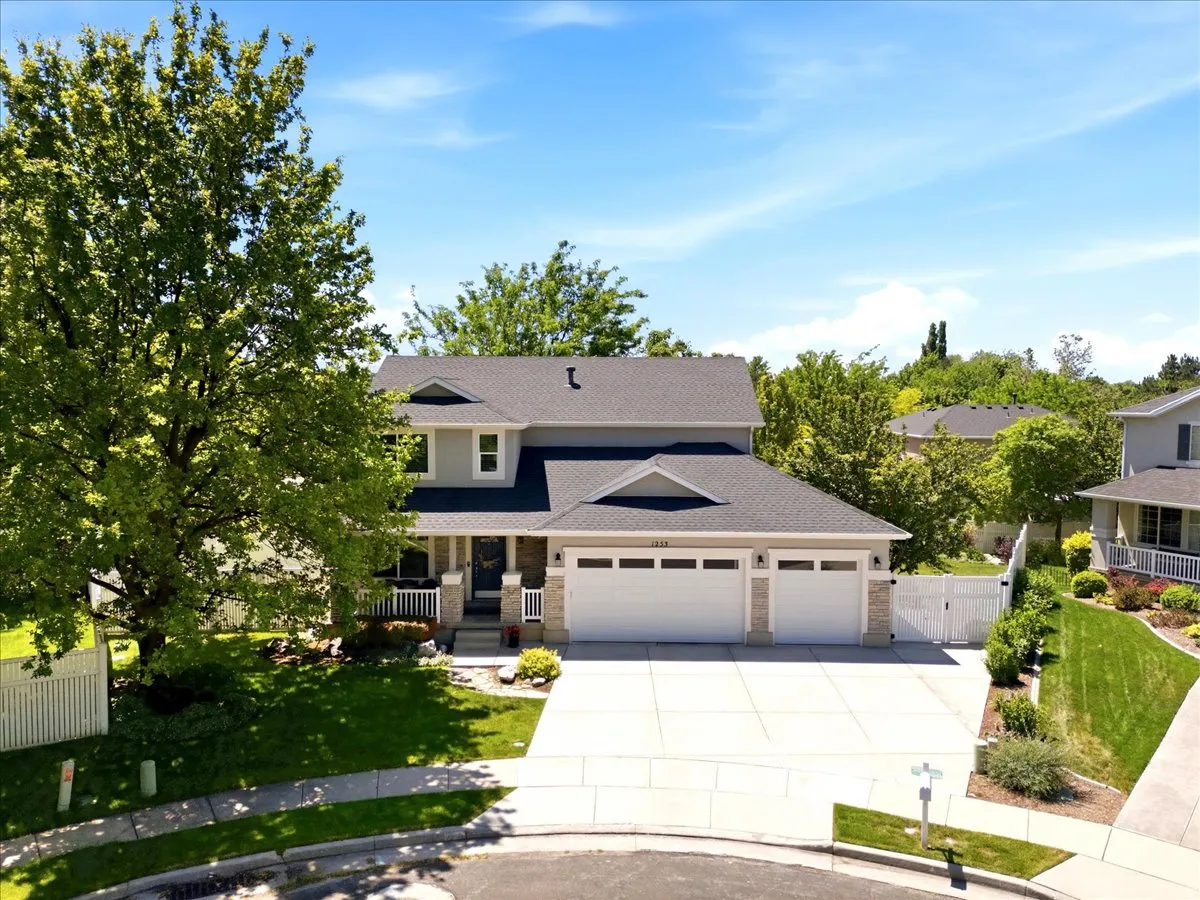 Two-story residence featuring a triple-stall garage and extensive concrete driveway