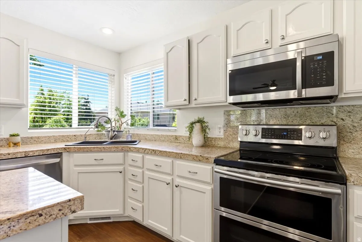 Kitchen featuring light-toned cabinetry, granite countertops, and stainless steel appliances