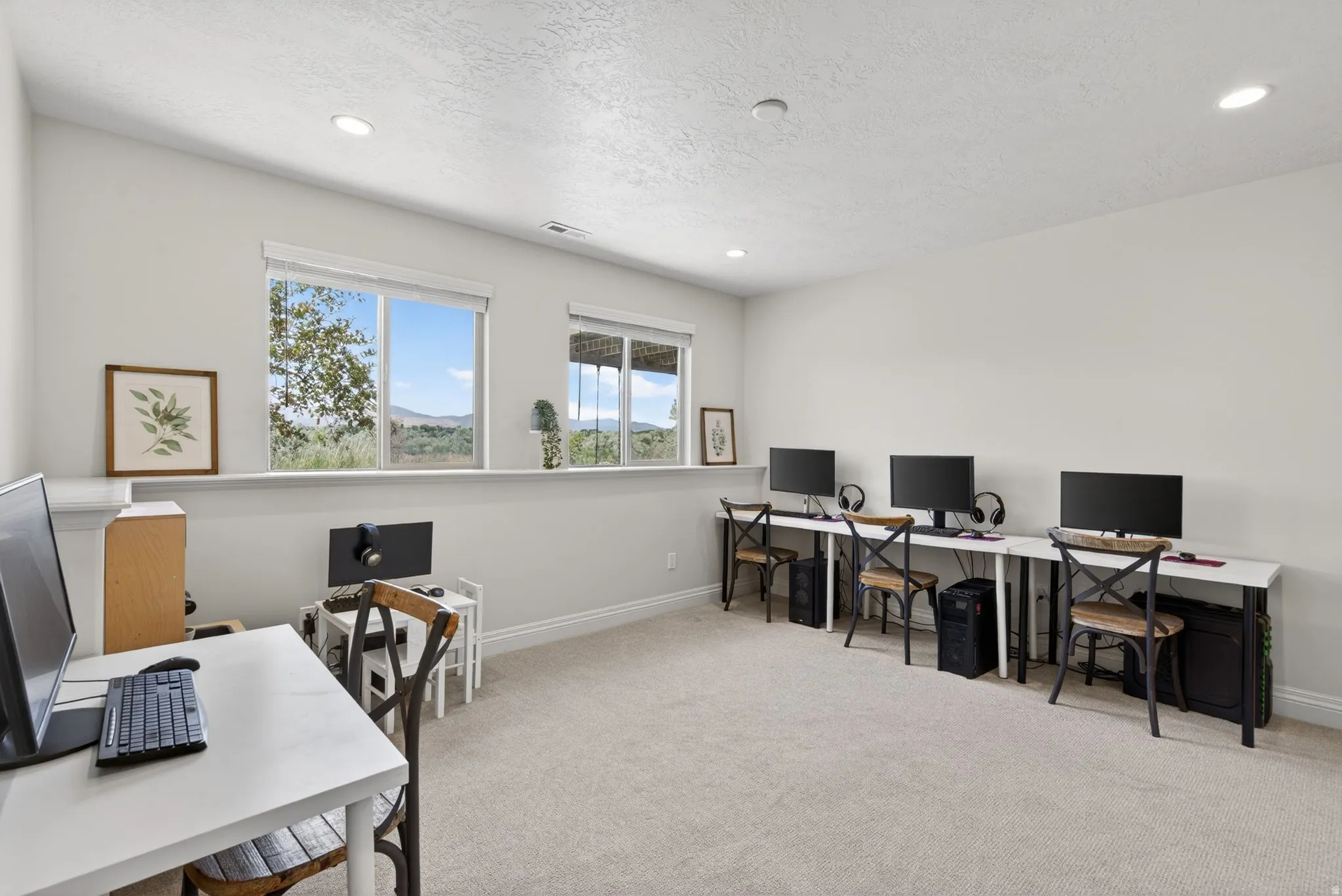 Spacious room featuring neutral carpeting, recessed lighting, and multiple windows