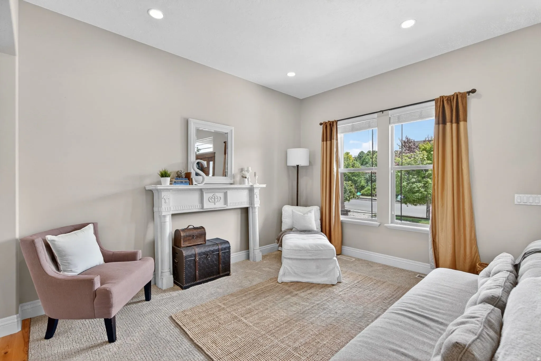 Bright living space featuring a decorative mantelpiece, recessed lighting, large windows, light-toned walls, and wood-finish flooring