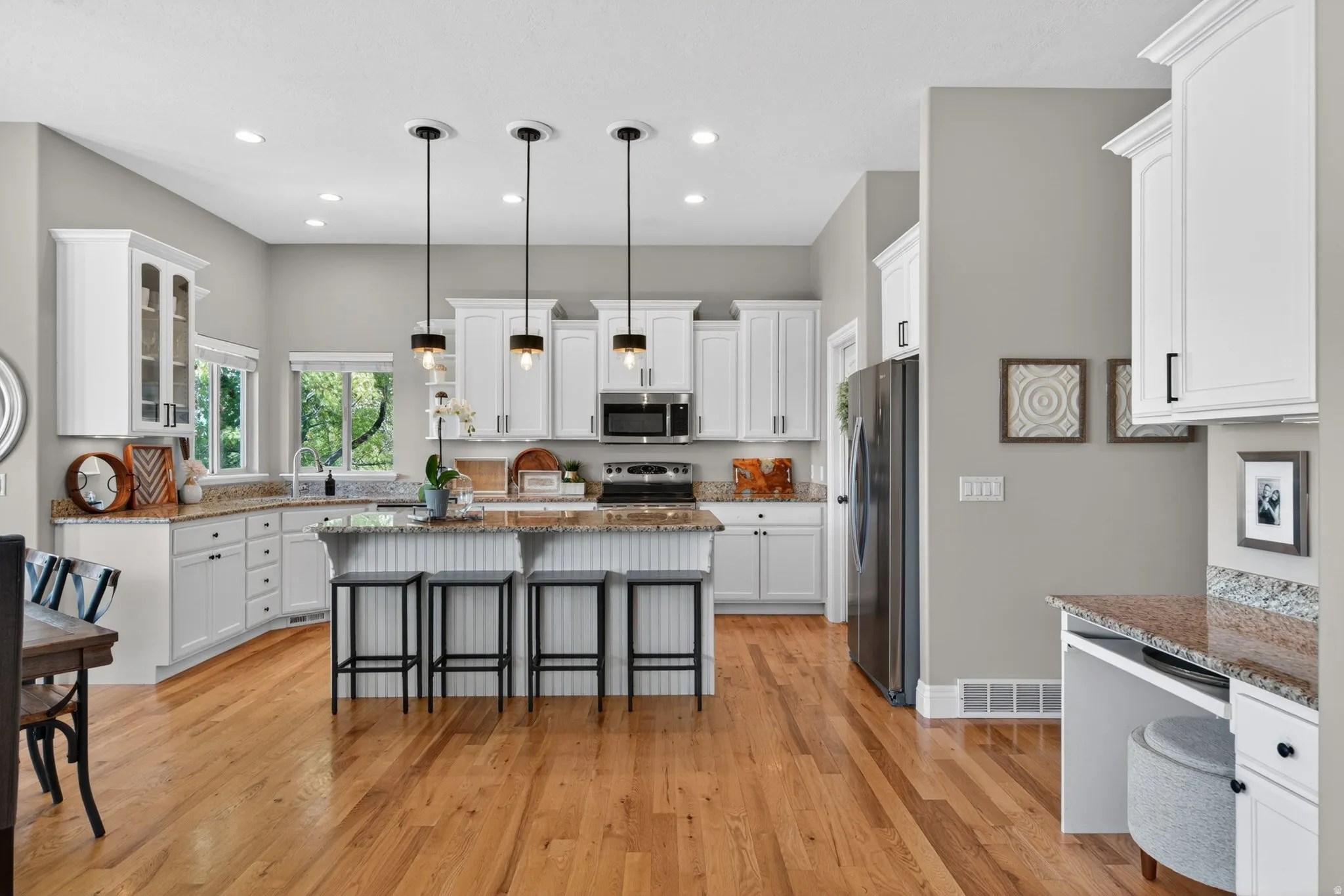 Spacious kitchen featuring an island with beadboard detailing, white shaker-style cabinetry.