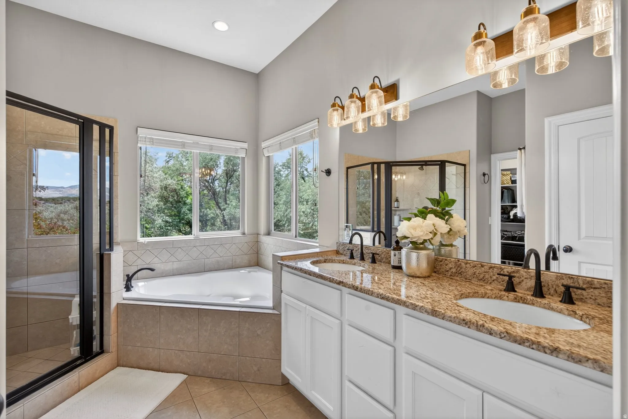 Bathroom featuring a dual vanity with granite countertops, undermount sinks, and matte black fixtures