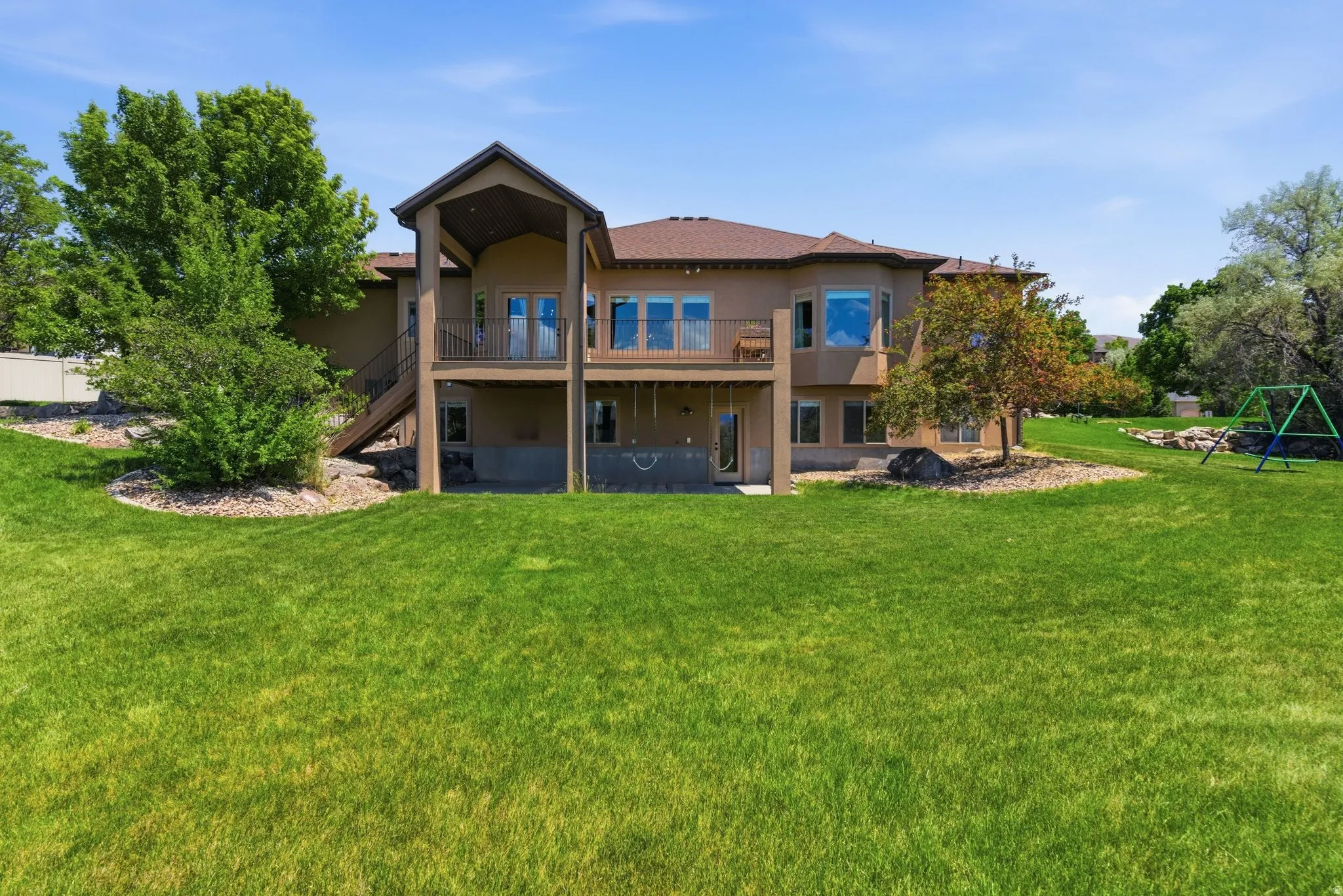 Expansive rear facade featuring a large grass lawn