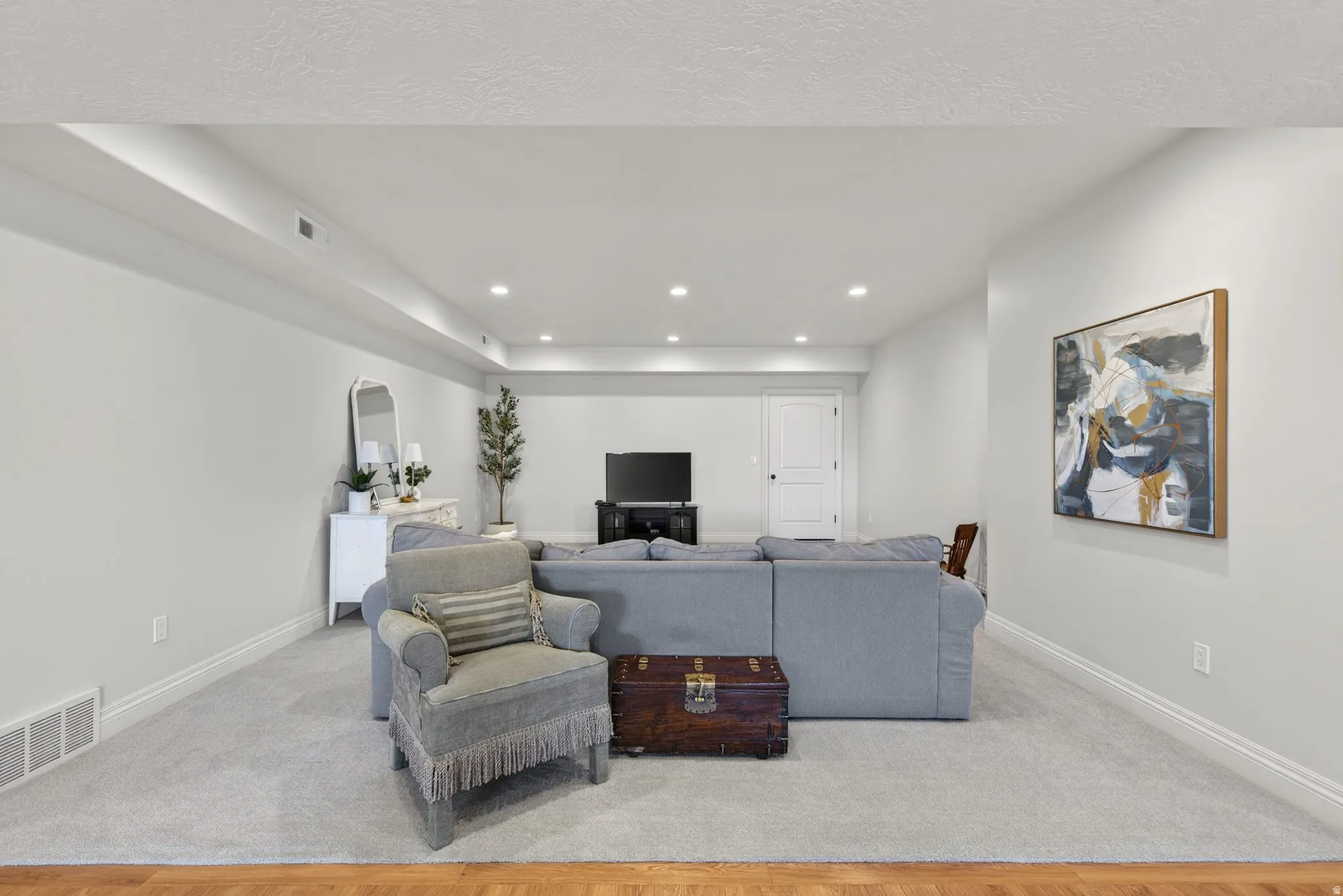 Spacious recreation room featuring recessed lighting, light-toned carpeting, and white baseboards