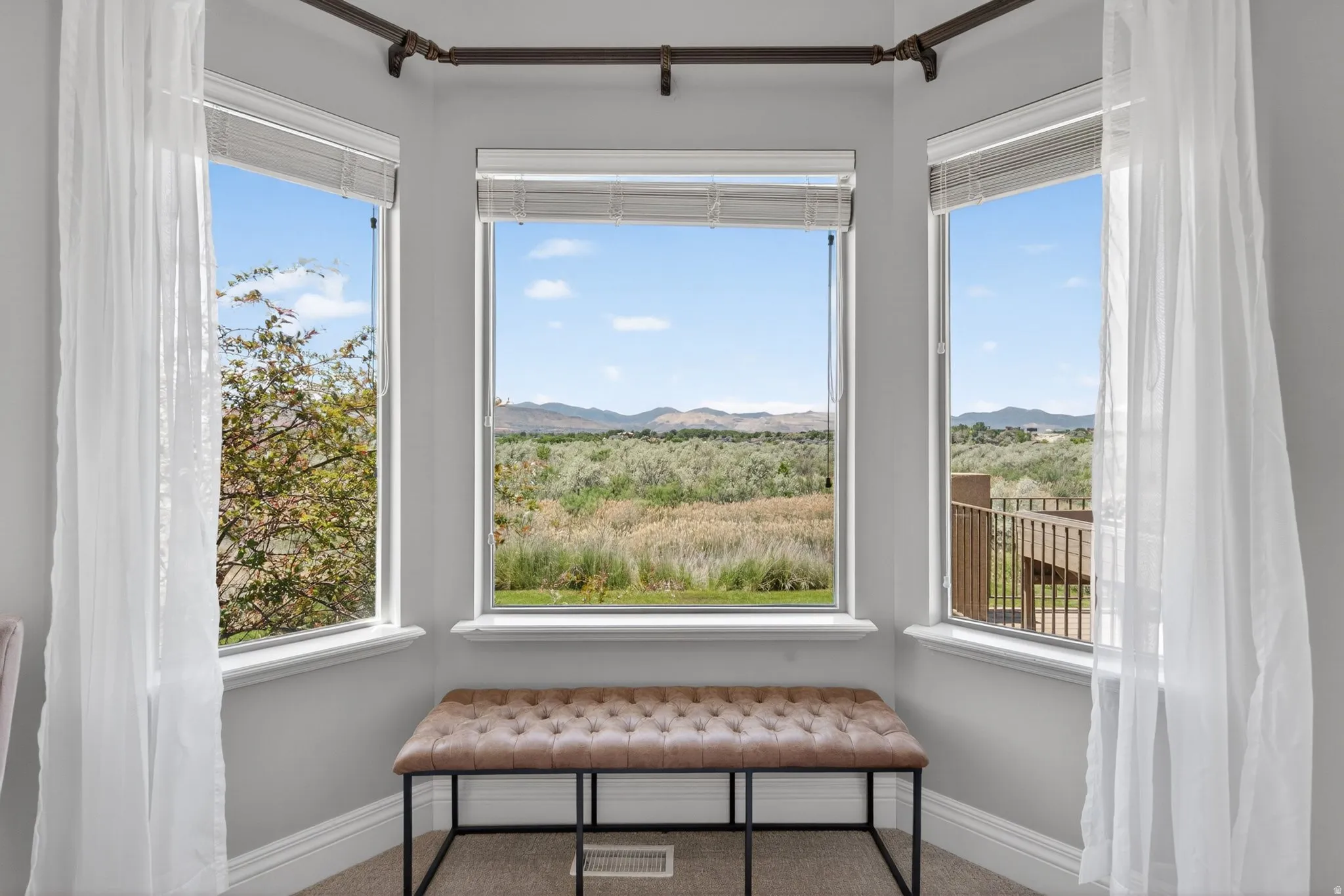 Bay window feature with multiple panes framing expansive natural scenery