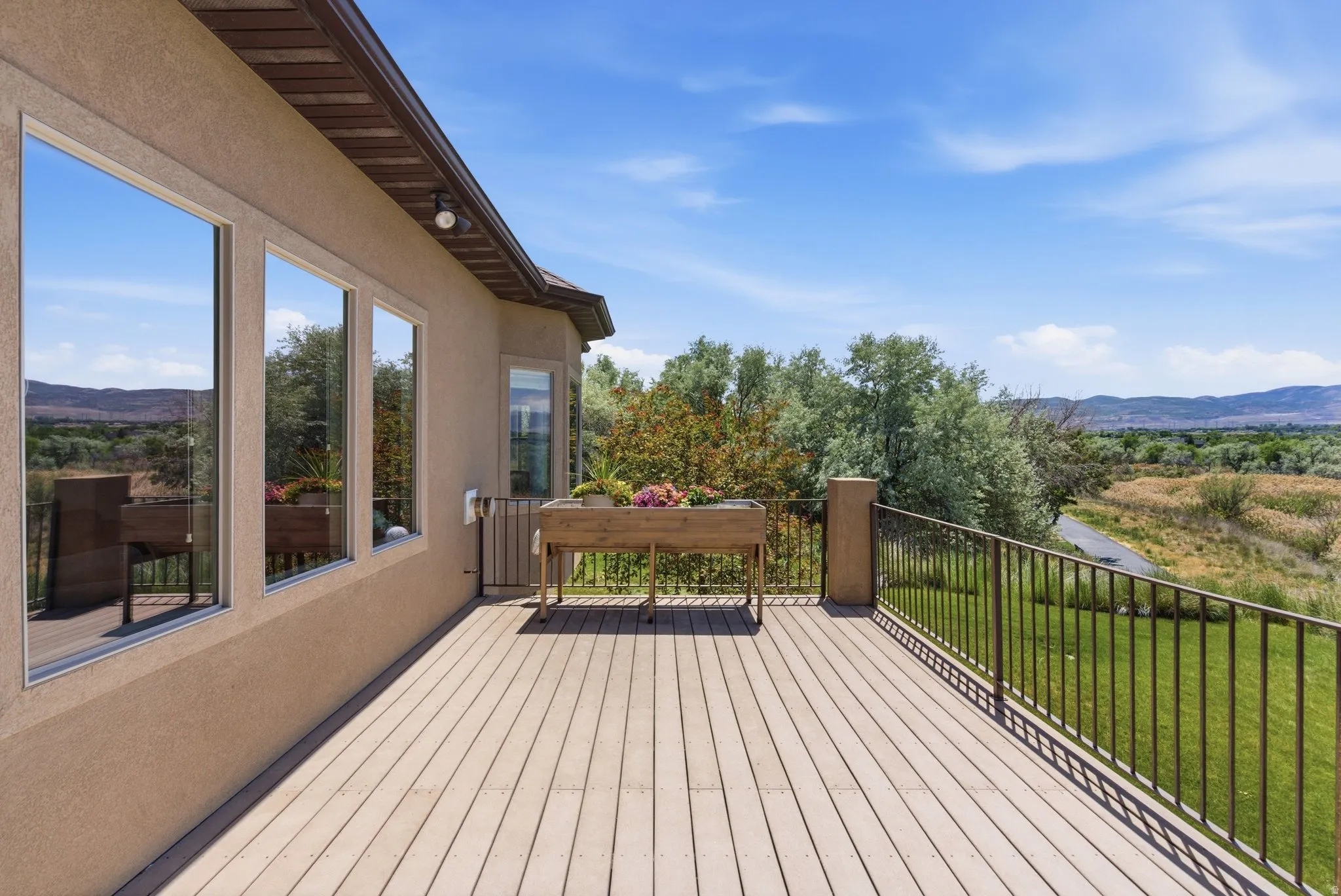 Expansive outdoor deck featuring composite decking, metal railings, and stucco exterior