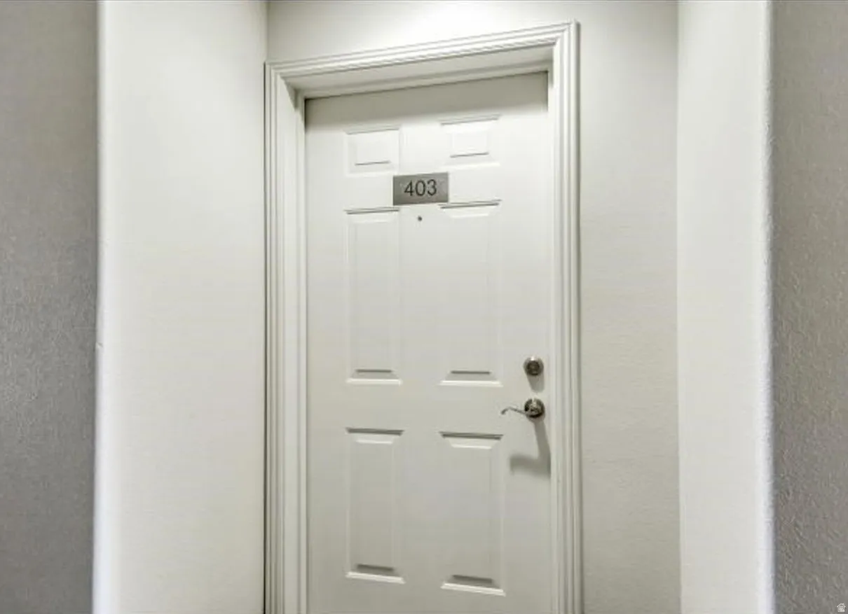 White paneled door with brushed nickel hardware and a numeric address plaque