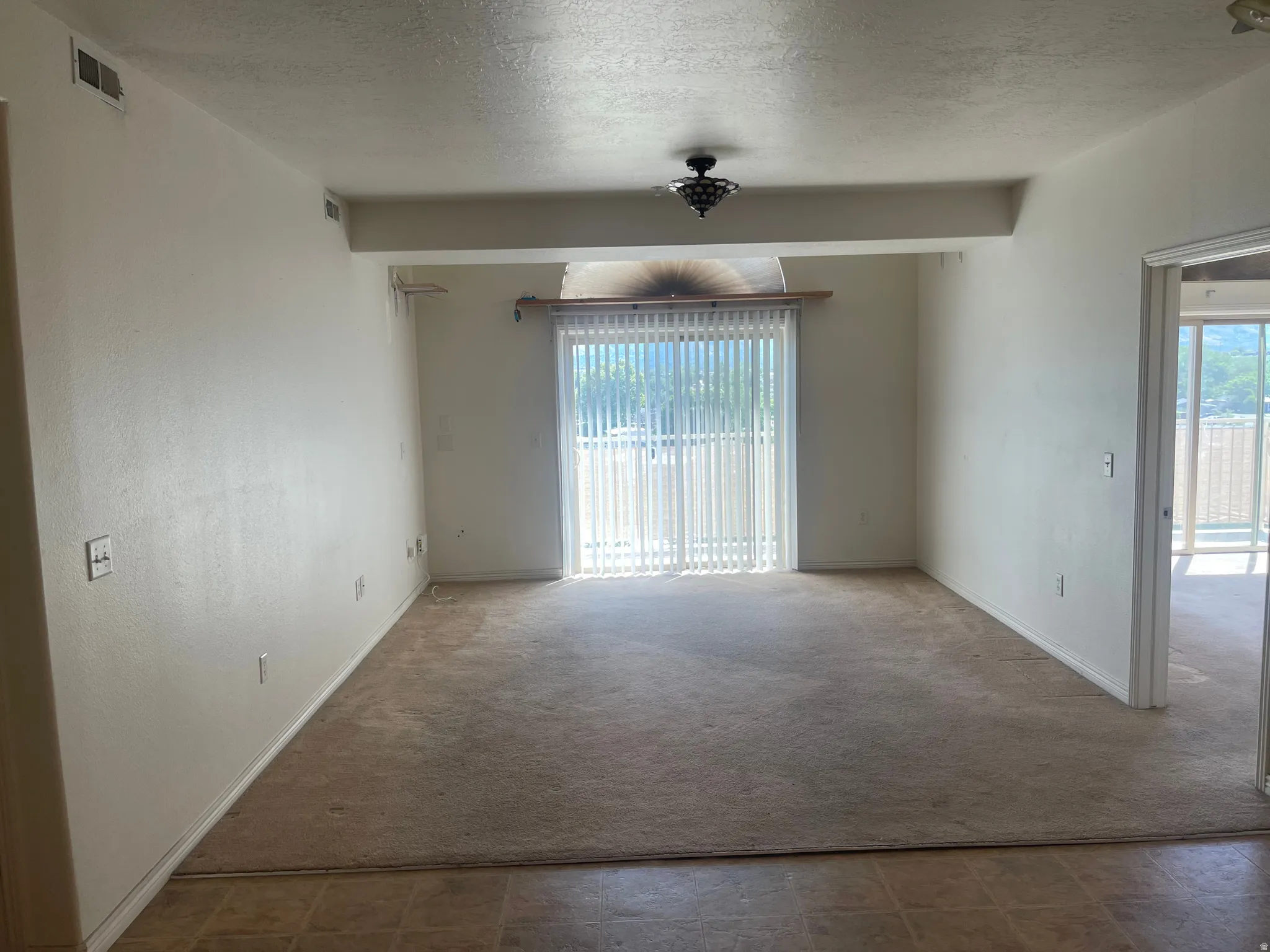 Spacious room featuring neutral carpeting and light-toned walls