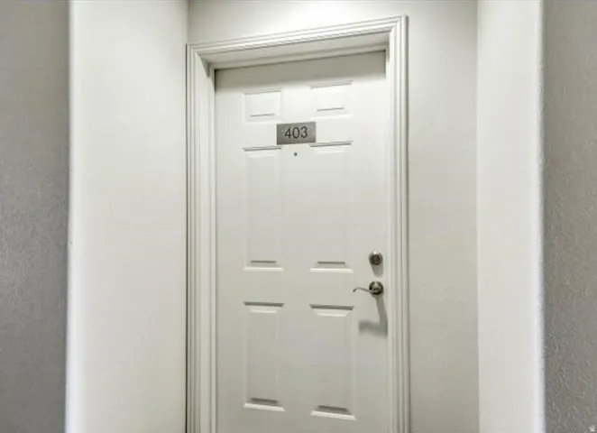 White paneled door with brushed nickel hardware and a numeric address plaque