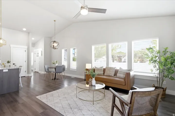 Vaulted ceilings enhance this living space featuring wood-finish flooring and light gray walls