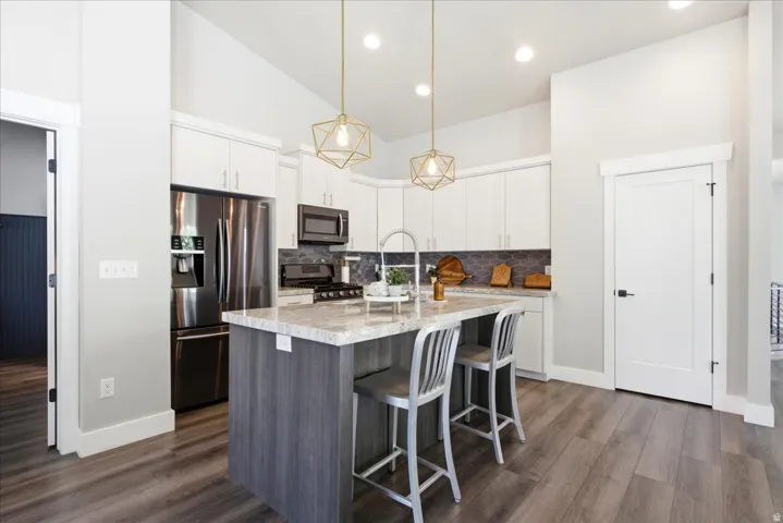 Modern kitchen featuring wood-finish flooring and a central island with a light-toned countertop