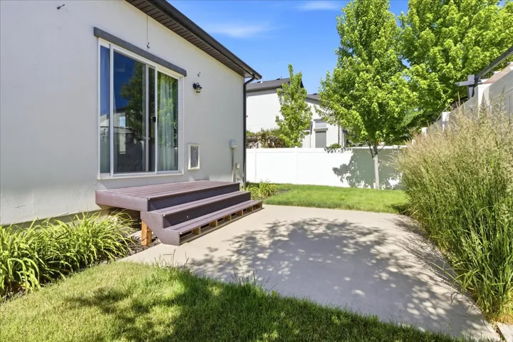 Private backyard featuring a concrete patio and a composite deck with two steps