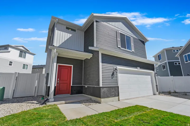 Contemporary two-story exterior featuring gray horizontal siding, white trim, a red entry door, an integrated garage with a white door, and a concrete driveway