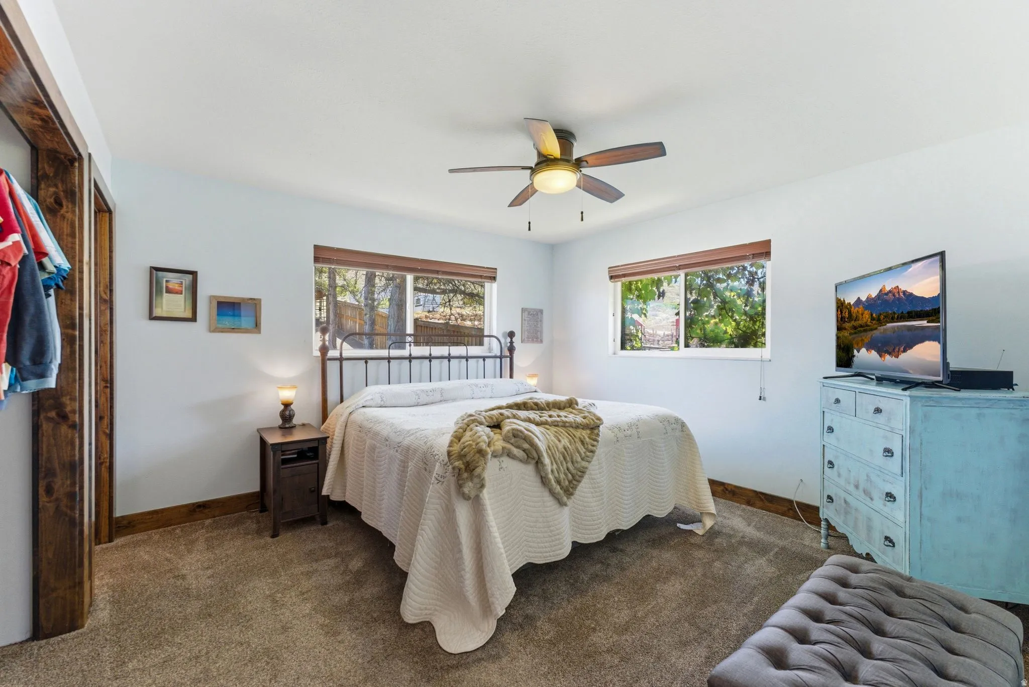 Spacious bedroom featuring light-toned walls and wood-finish trim