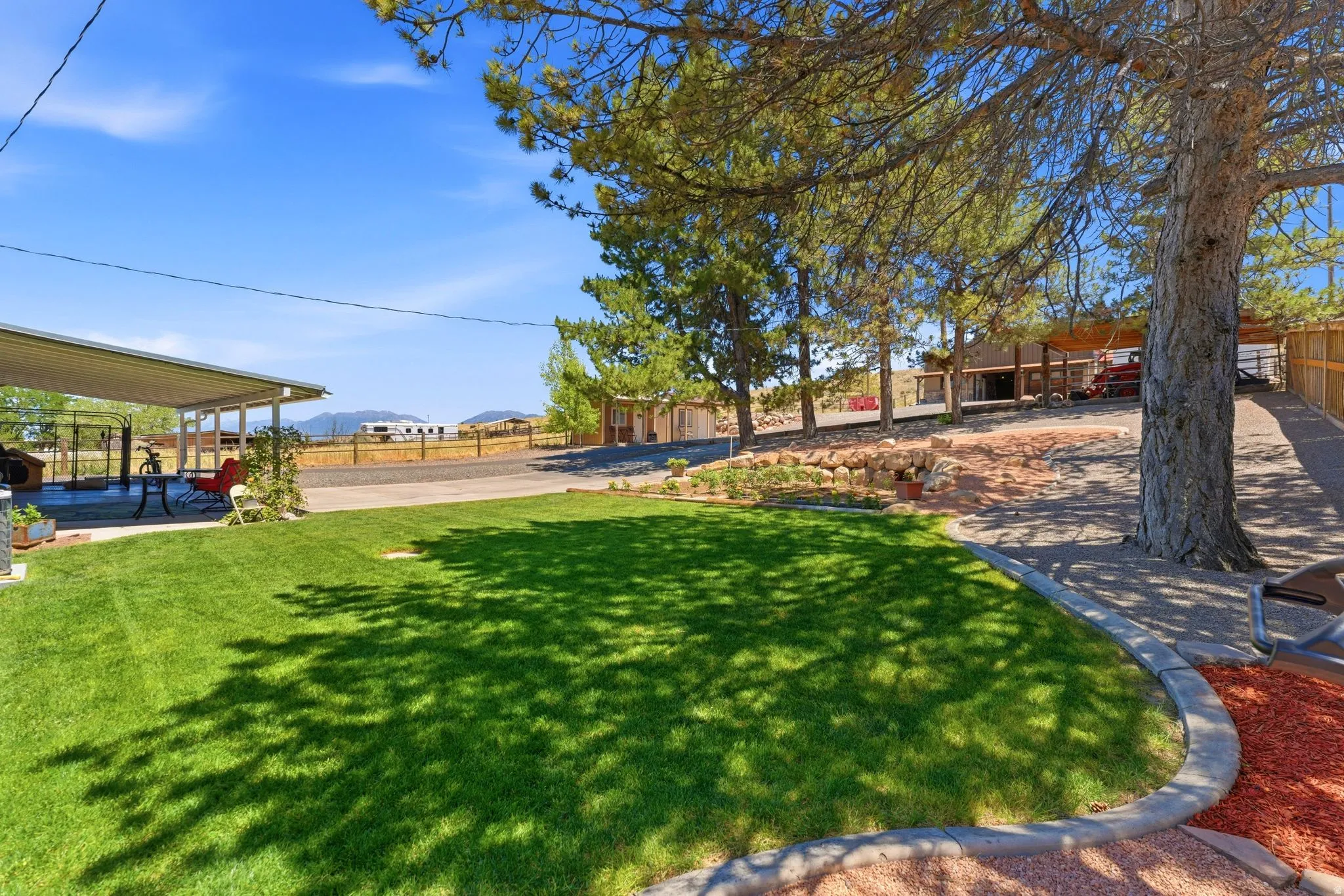 Expansive lawn bordered by concrete curbing and red-hued ground cover