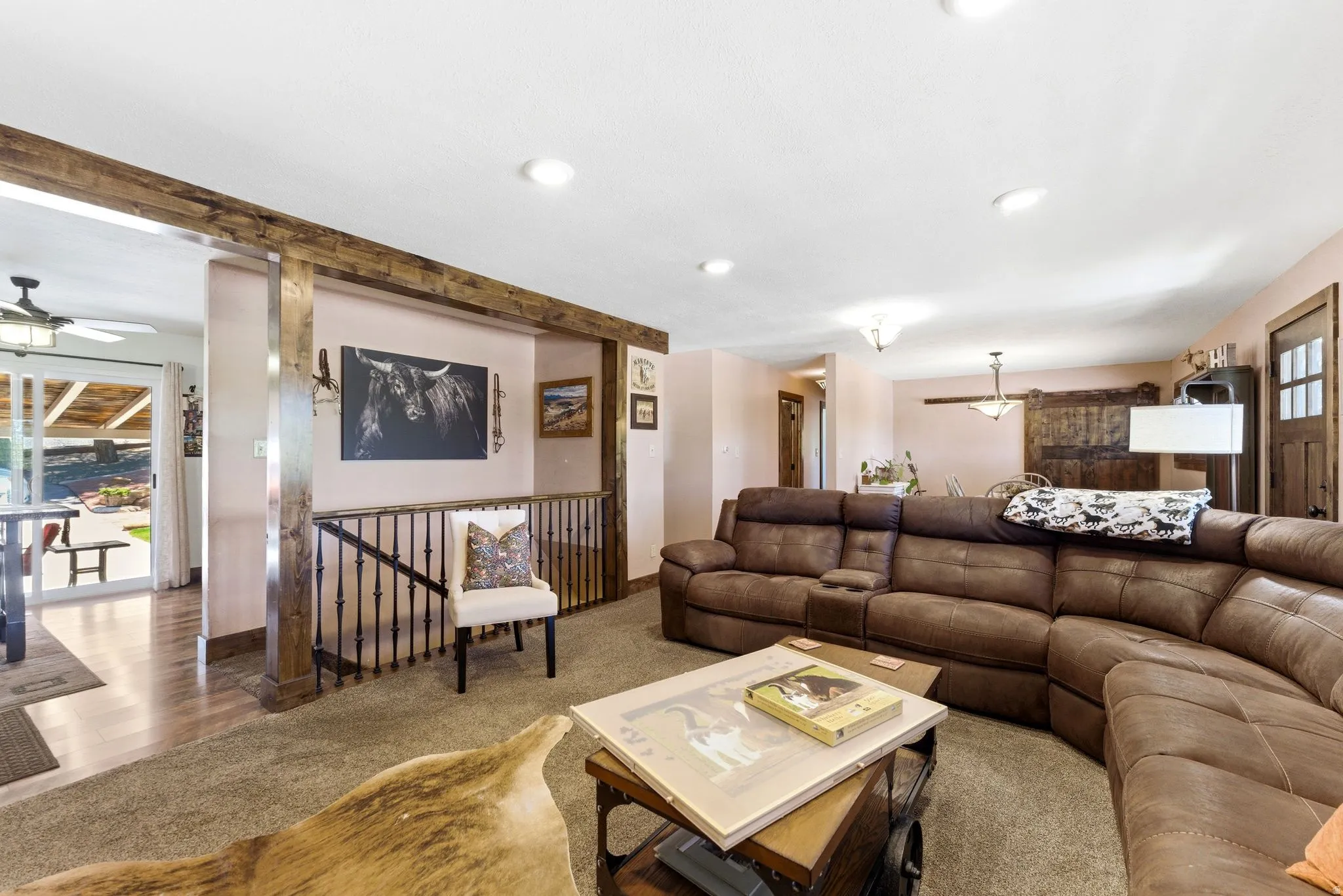 Spacious living area featuring exposed wood beams and recessed lighting