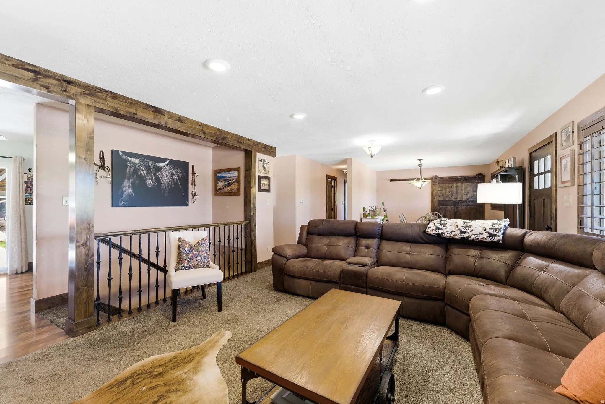 Spacious living area featuring exposed wood beams and recessed lighting
