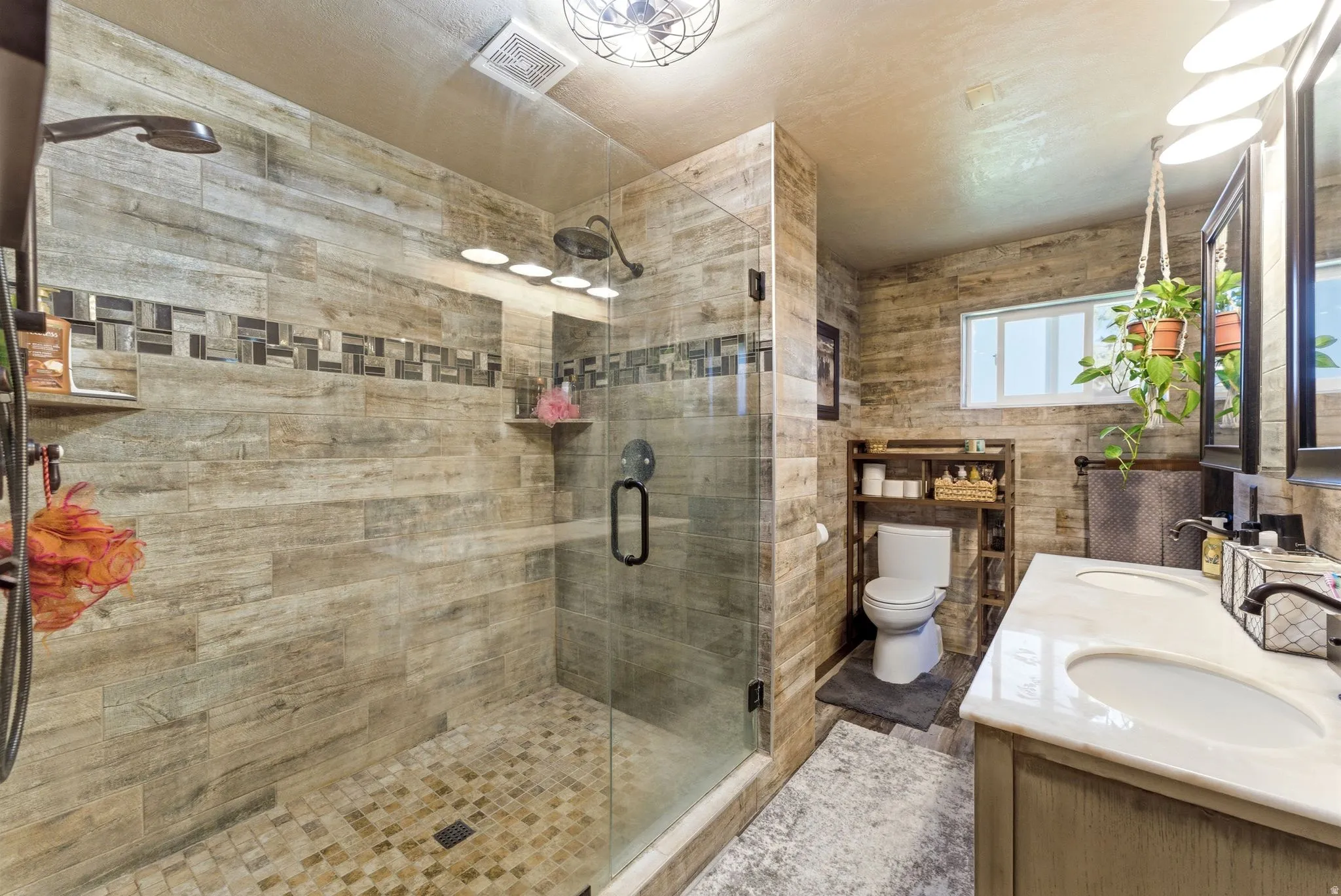 Bathroom featuring a walk-in shower with wood-finish tile and glass enclosure