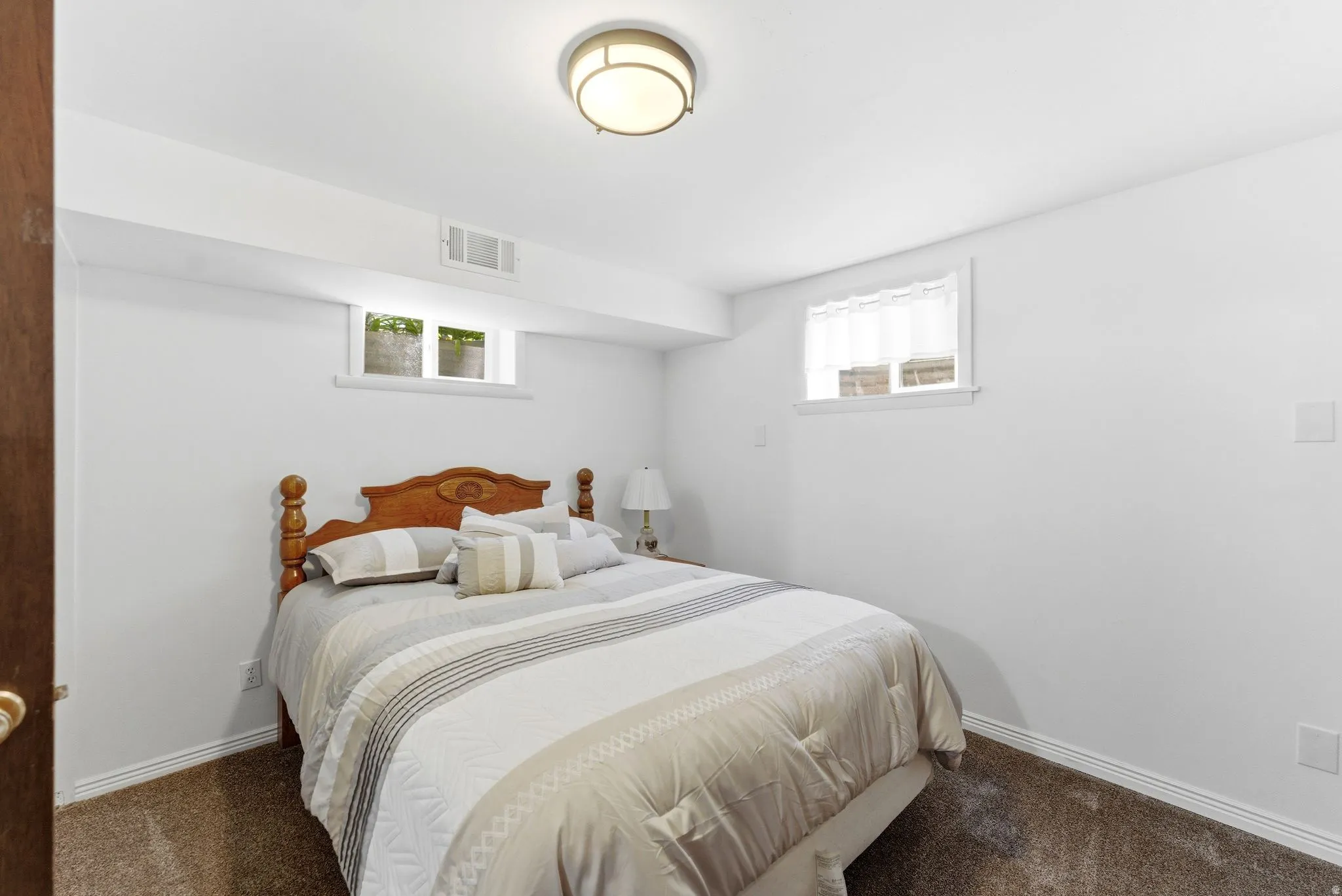 Spacious room featuring white painted walls, a large window with white trim, and a built-in recessed ceiling light
